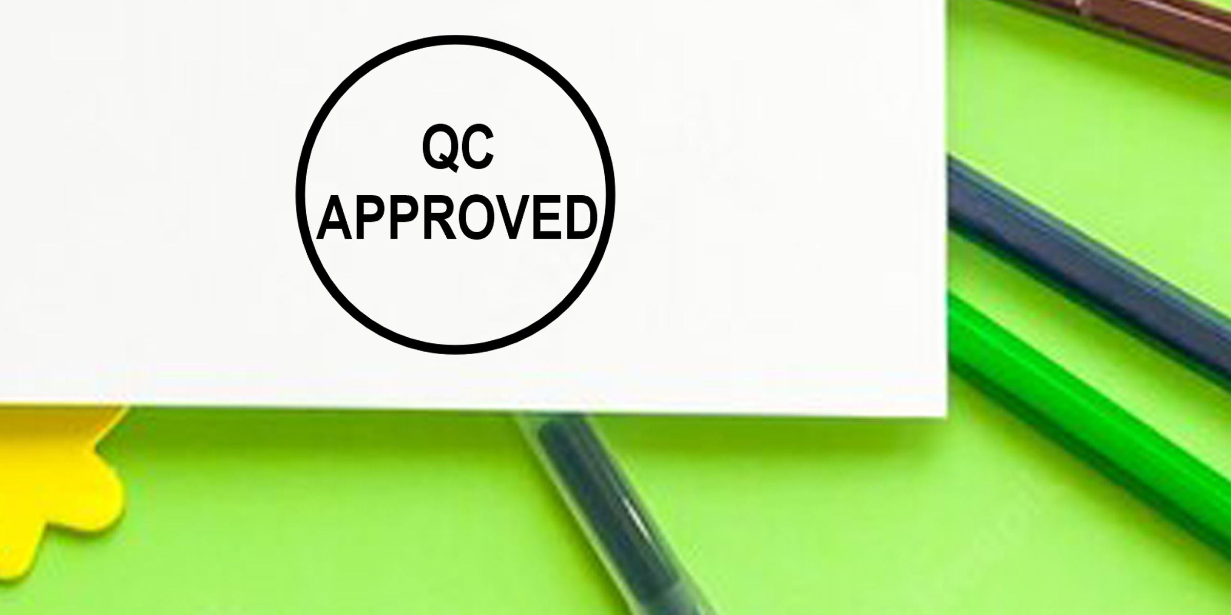 QC approved stamp on white paper with green background and colored pencils