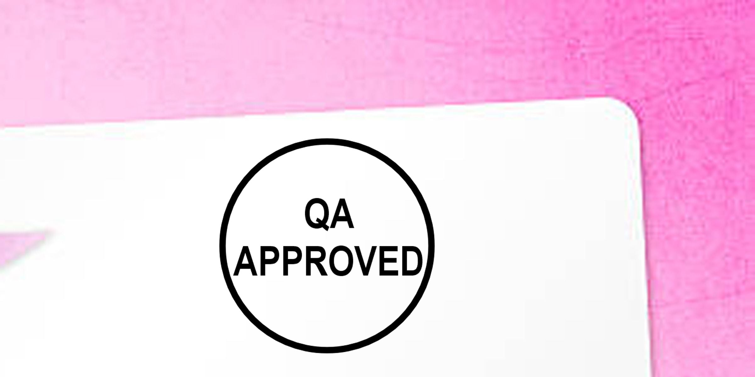 QA approved stamp on a white document against a pink background, indicating quality assurance approval.