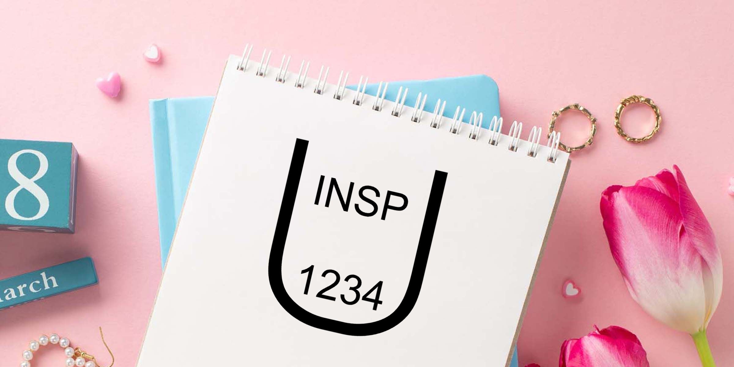 Pastel pink flat lay with a spiral notebook showing the INSP 1234 logo, surrounded by tulips, blue blocks, and decorative accessories