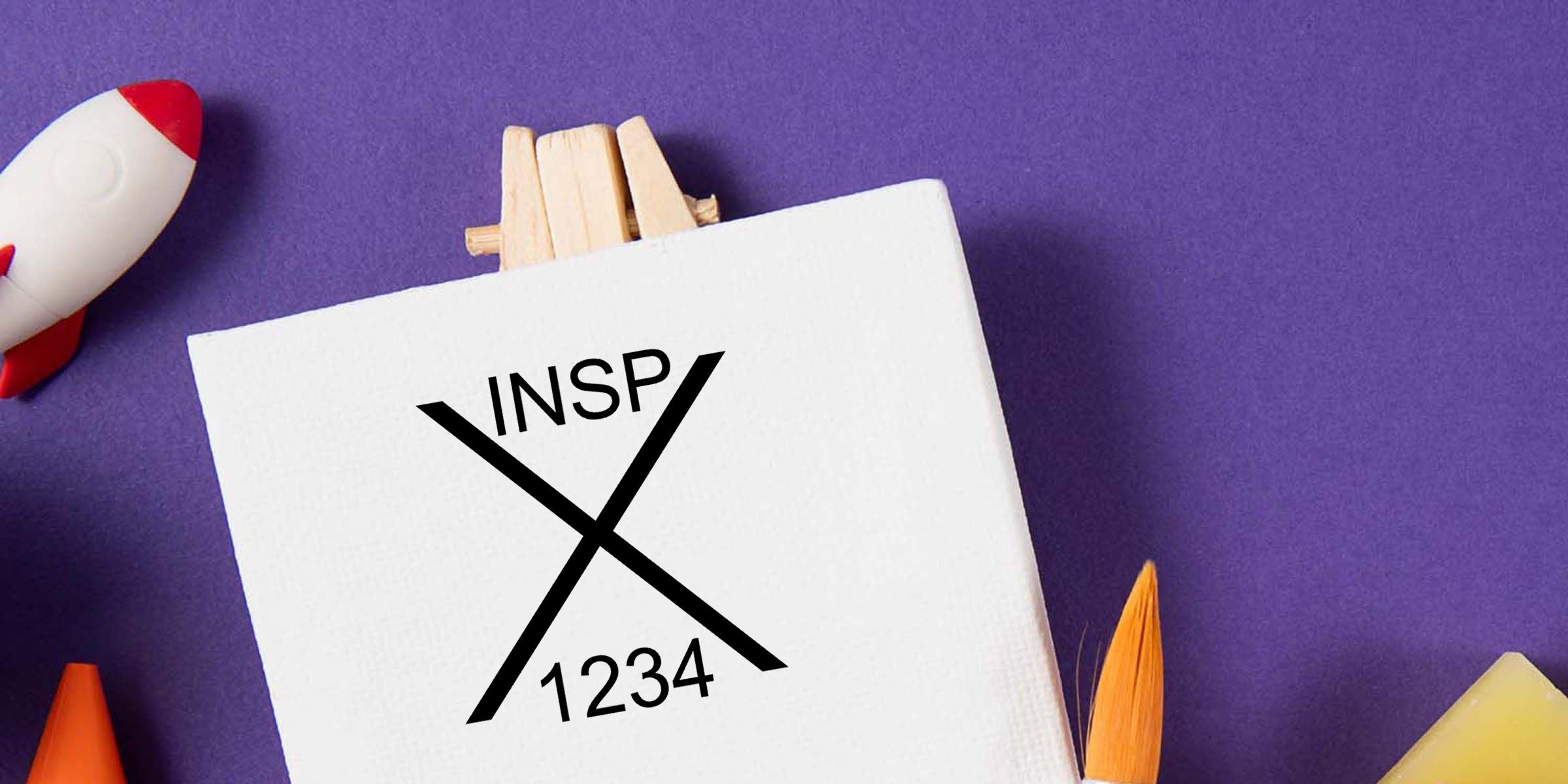 White card with INSPX1234 logo clipped by clothespins on a purple background, surrounded by colorful pencils and a toy rocket.