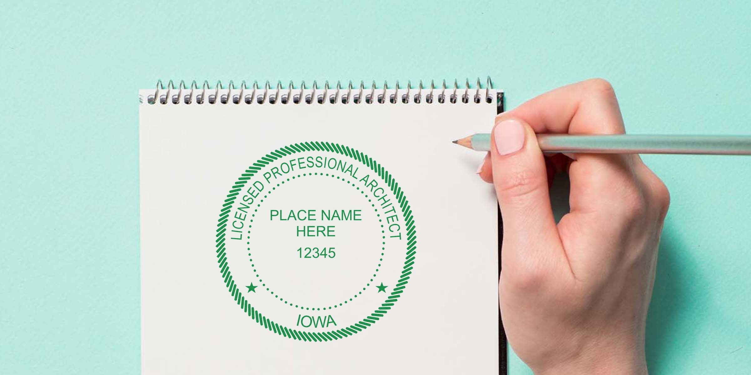Hand holding pencil over notepad with Iowa architect seal and licensed professional architect stamp, symbolizing architect certification in Iowa.