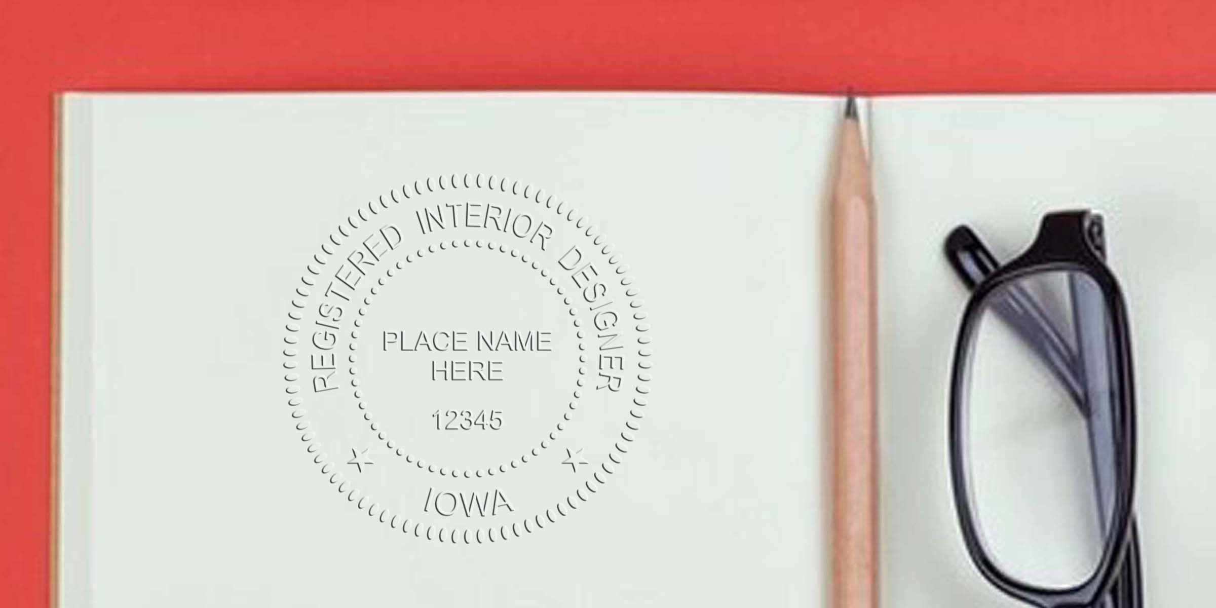 Registered interior designer stamp on notebook page with pencil and black glasses on red background, highlighting Iowa interior design standards and seal size requirements.
