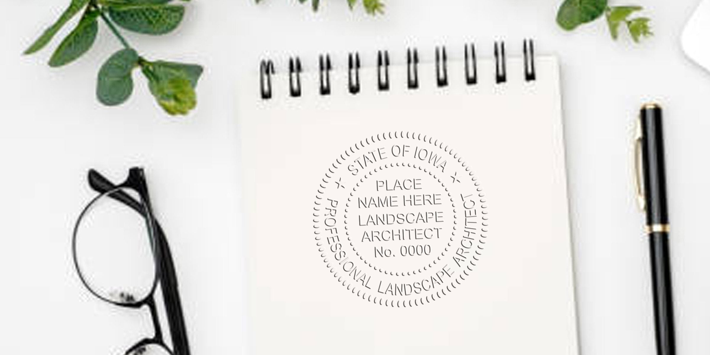 Iowa Landscape Architect Seal on white notepad with black pen and glasses on desk, symbolizing professional landscape architect certification.
