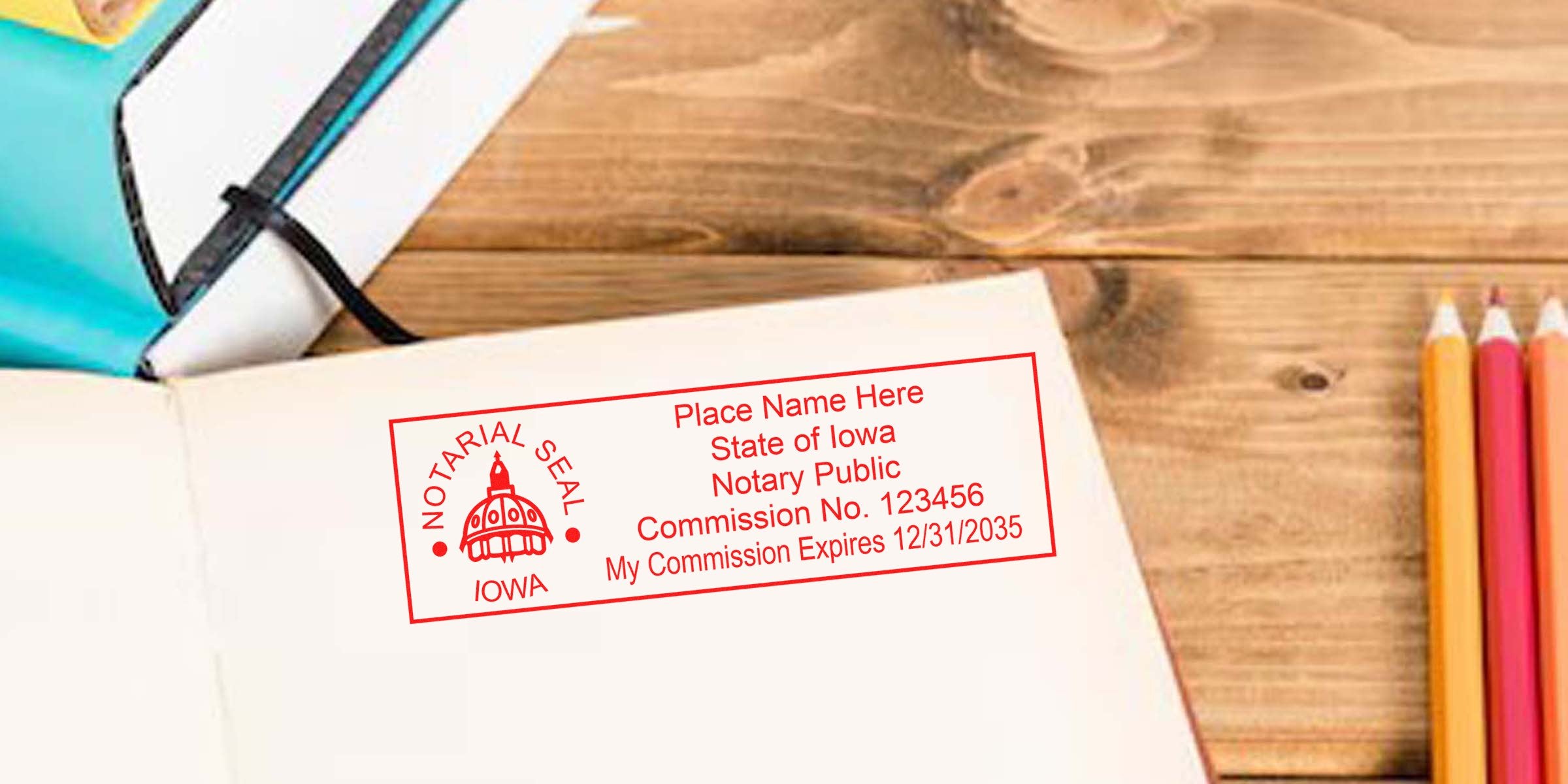 Iowa notary public stamp on open notebook with colored pencils on wooden desk, highlighting Iowa notary stamp renewal and renewal requirements.