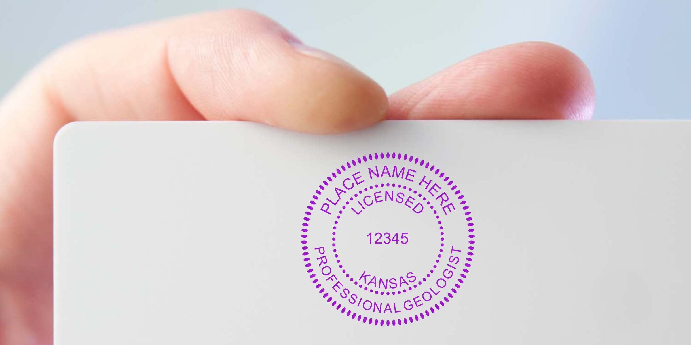 Hand holding Kansas Geologist Stamp, showing the professional certification renewal process.