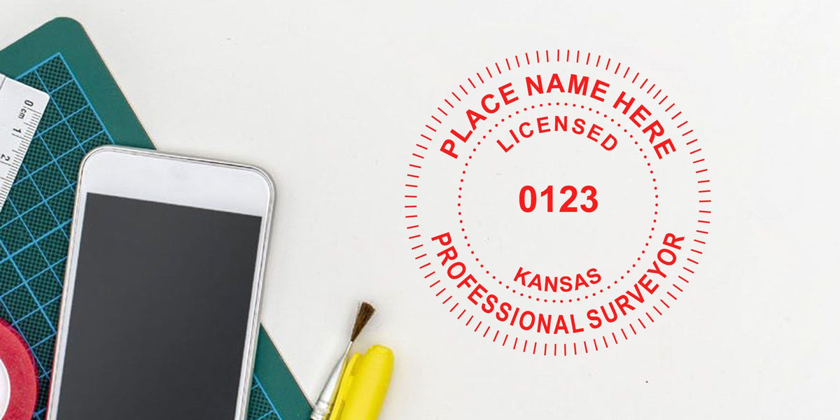 Kansas land surveyor license stamp, seal embosser tips, smartphone, and stationery tools on white background.