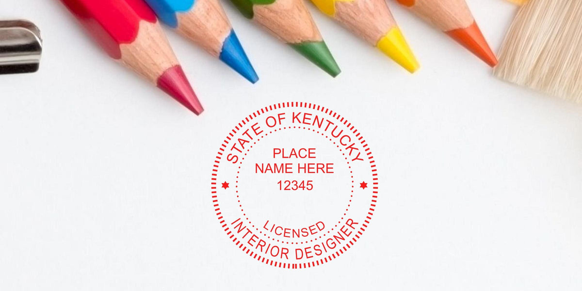 Colored pencils and paintbrush next to Kentucky interior designer license and stamp on white background.