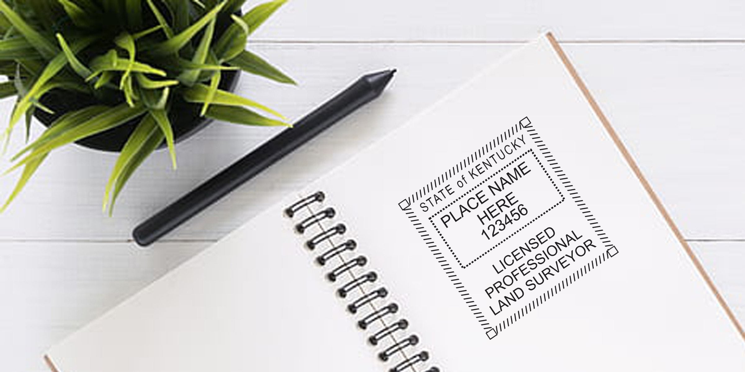 Kentucky land surveyor seal stamped on a notebook beside a pen and plant, showcasing a land surveyor seal template.