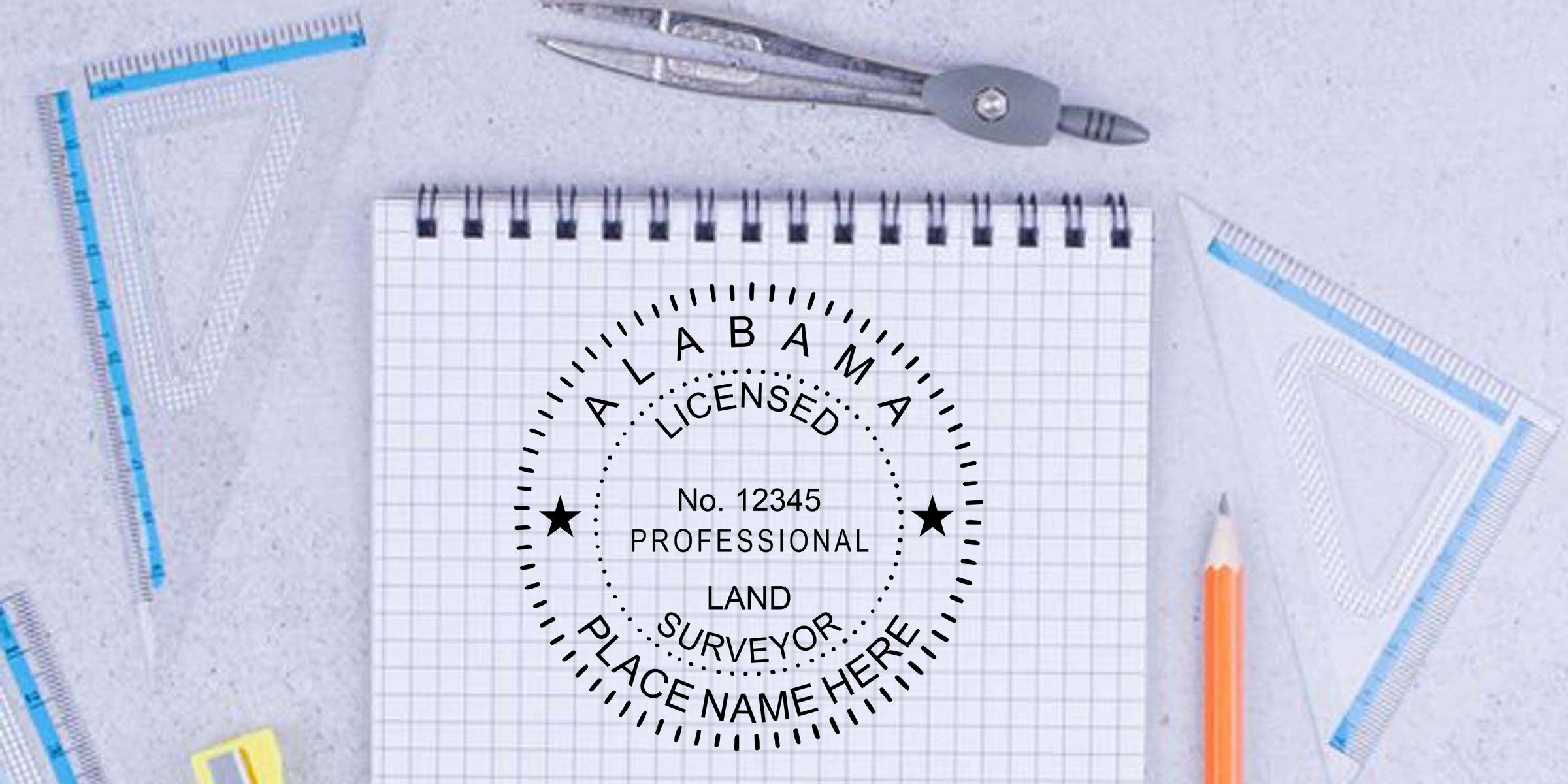 Land surveyor professional license stamp on graph notebook with drafting compass, rulers, and pencils arranged on a tabletop workspace