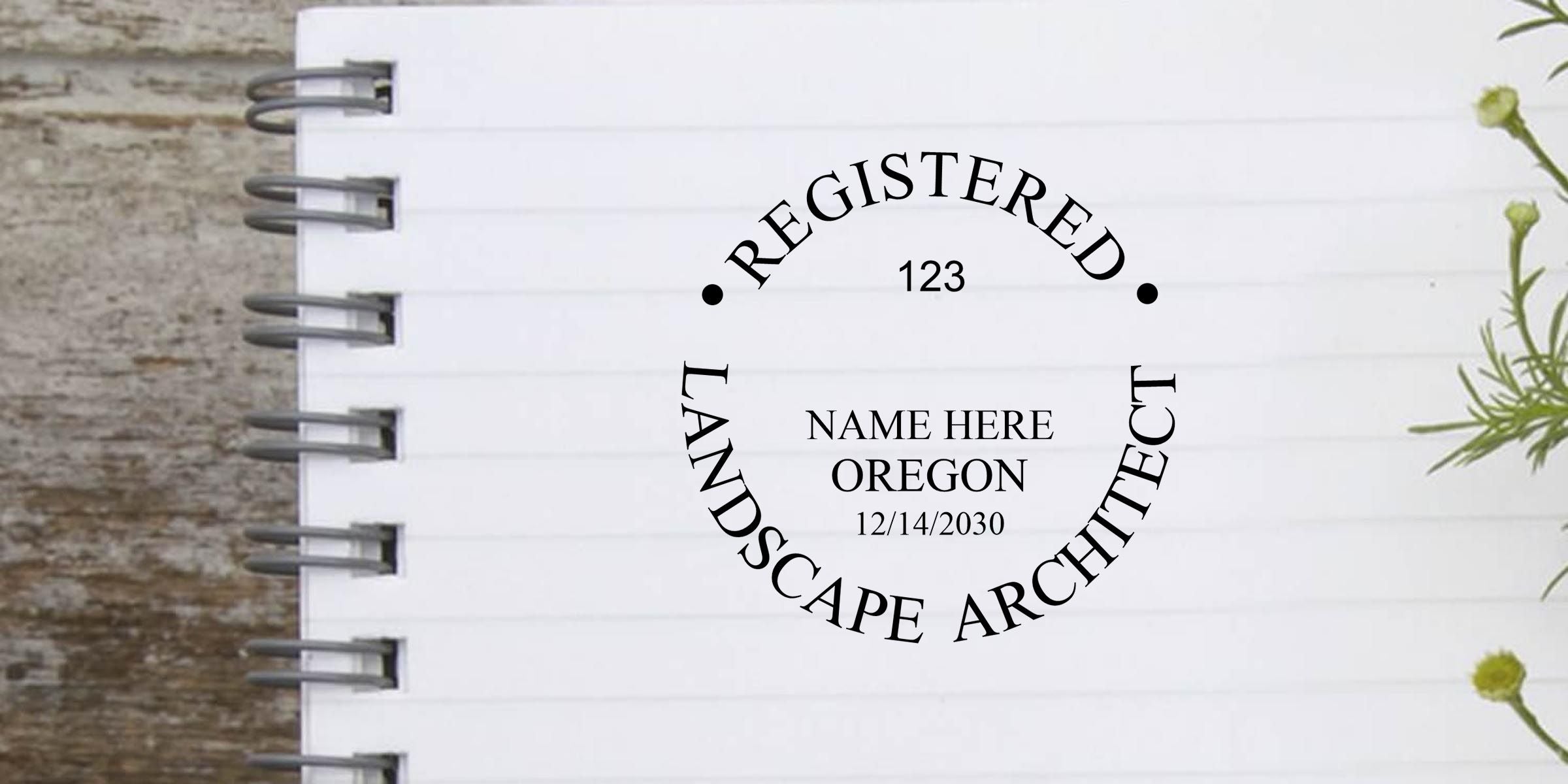 Custom registered landscape architect seal design on a white spiral notebook page, featuring Oregon, name placeholder, license number 123, and date 12/14/2030.