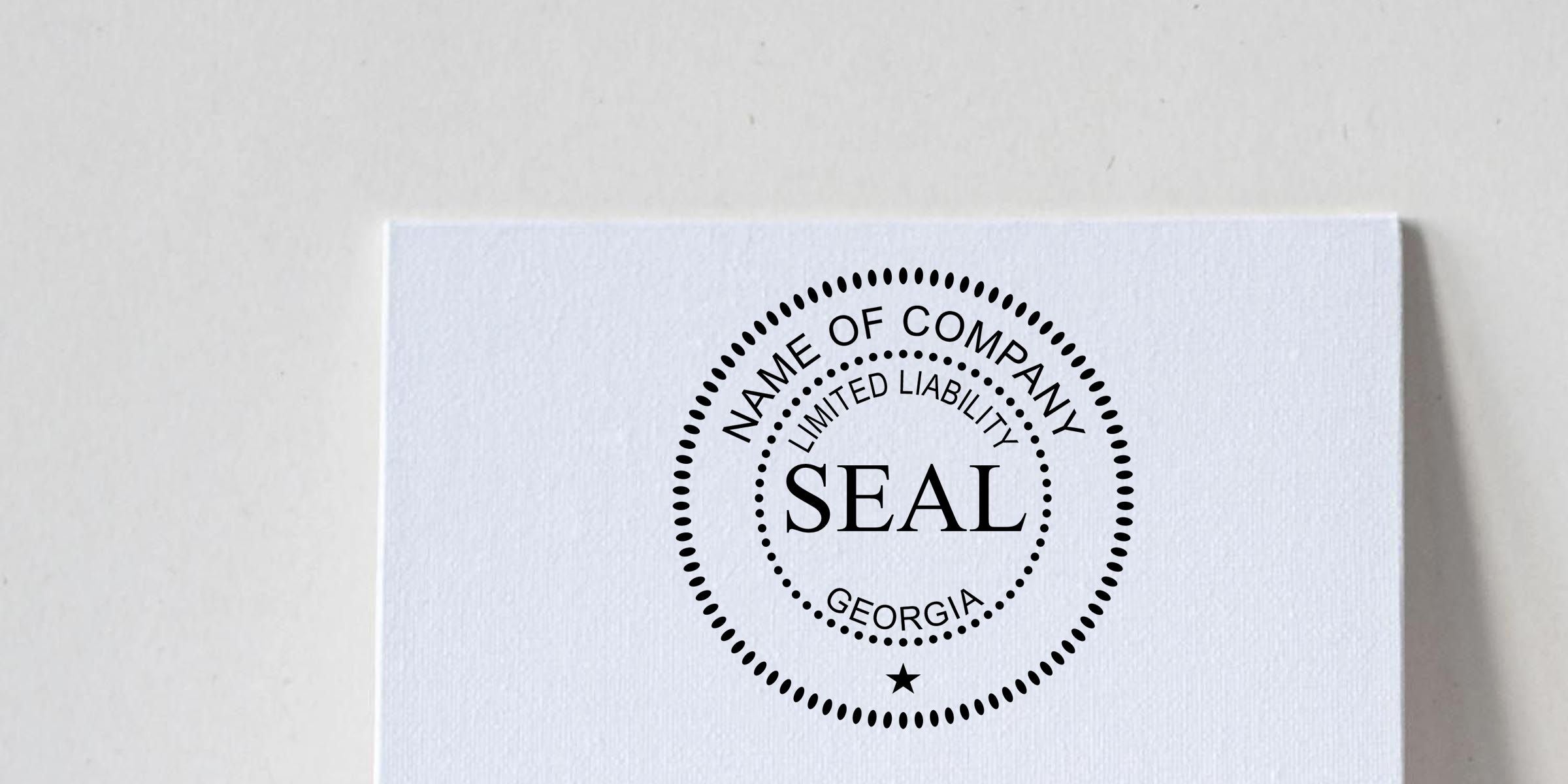 White textured paper with a black corporate seal stamp reading “Name of Company Limited Liability Seal Georgia” on a clean minimal background