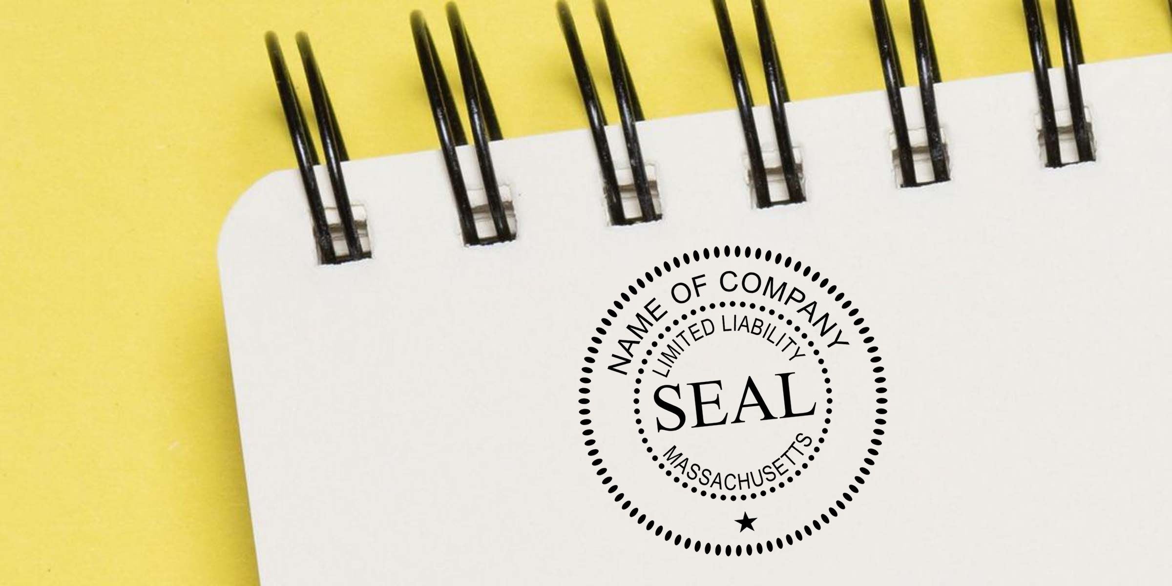 Blank spiral notebook with a corporate seal stamp reading company name, limited liability, and Massachusetts on a yellow background