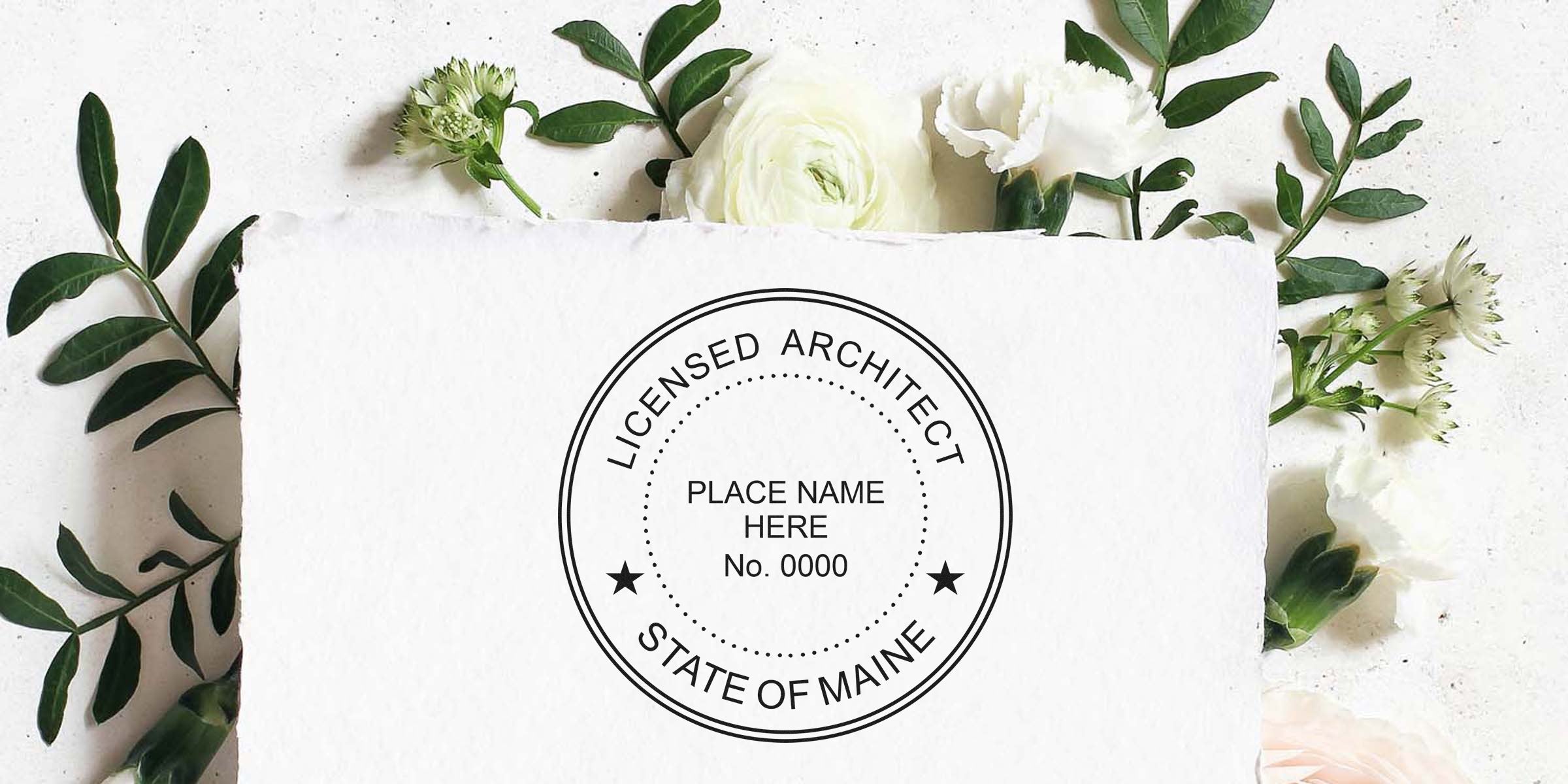 Licensed architect stamp from Maine on white paper, framed by green leaves and white flowers, featuring Maine architect stamp cost and pricing tips.
