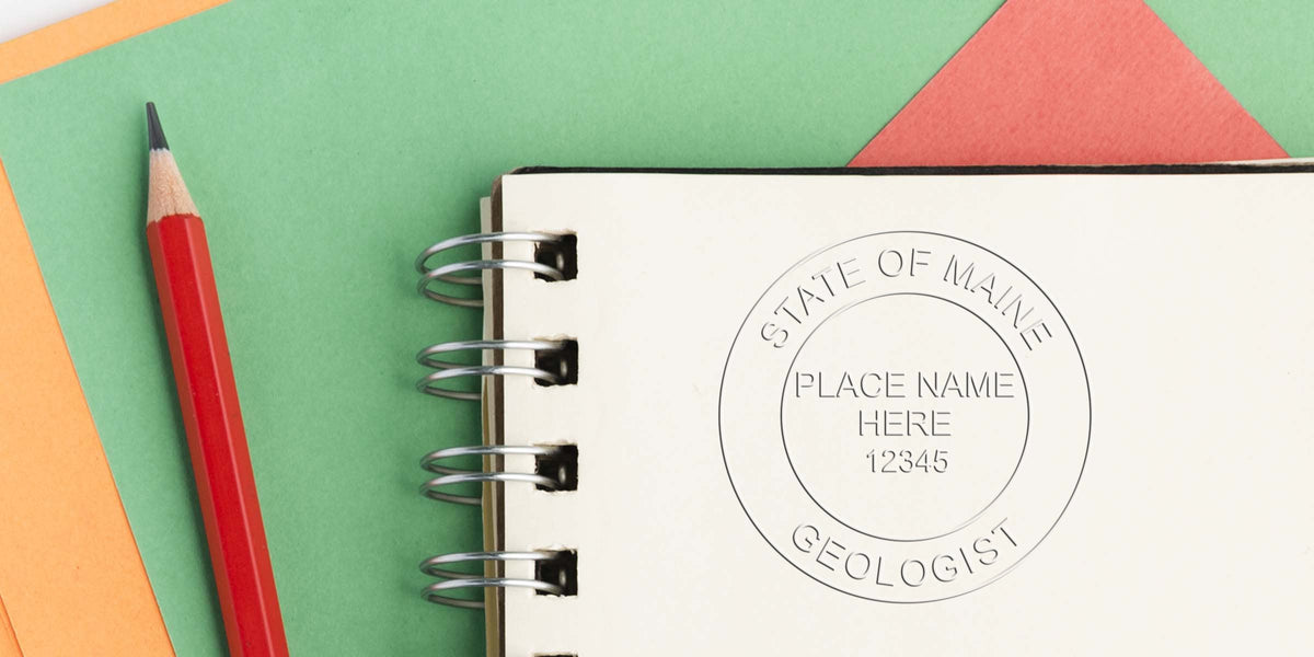 Red pencil next to spiral notebook with Maine State Geologist Stamp on bright paper, ideal for Geologist Stamp Shopping Guide.