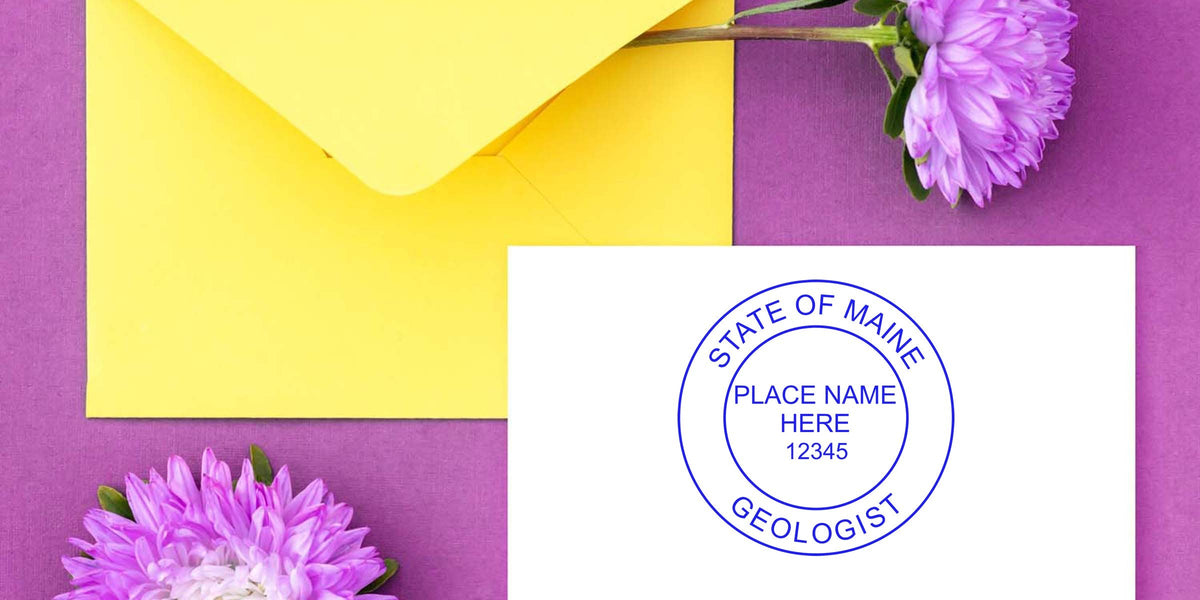 Custom Maine geologist stamp on white paper with yellow envelope and purple flowers, set against a purple background, highlighting Maine geologist stamp choices.
