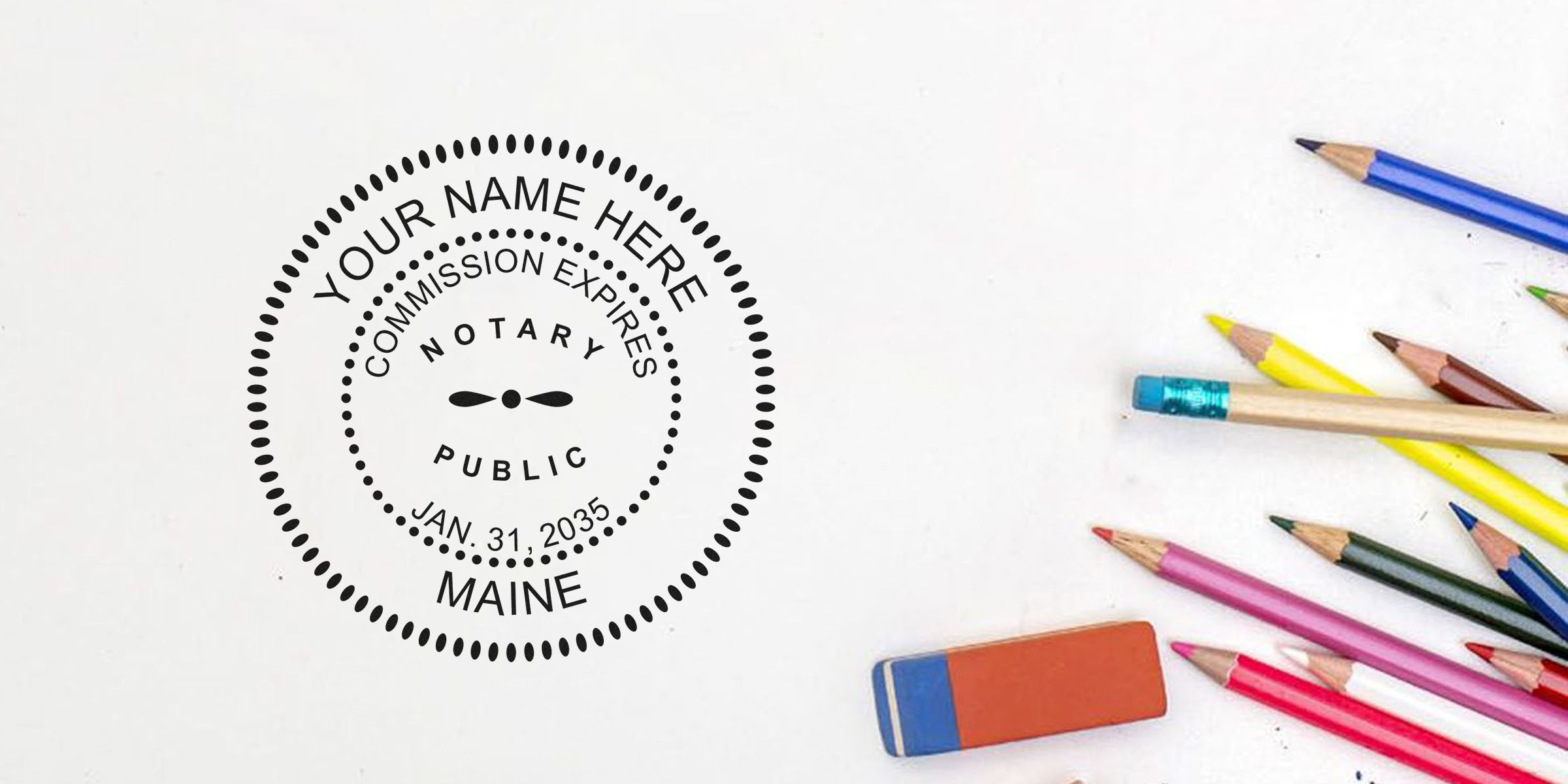 Maine notary stamp with commission expiration date in standard format, next to colored pencils and eraser on white background.
