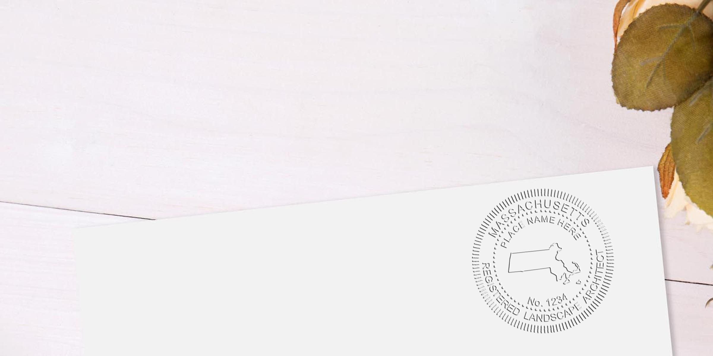 Massachusetts landscape architect seal on white paper with autumn leaves on a wooden background, featuring the registered landscape architect seal of Massachusetts.