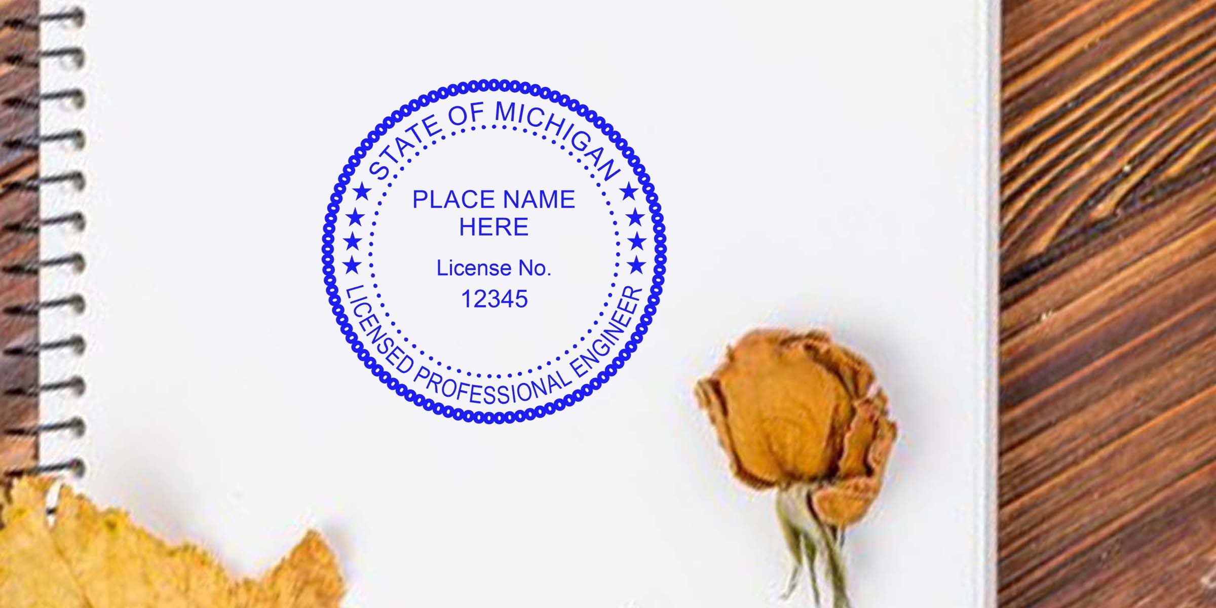 Michigan Professional Engineer Seal stamp on white notebook with dried flower, wooden table background, showcasing Michigan PE Seal and its requirements.