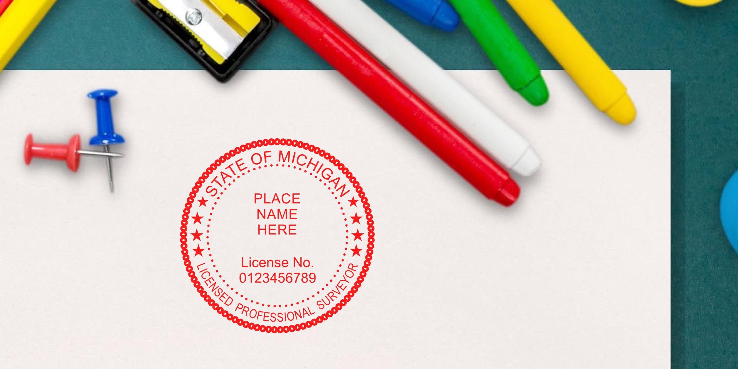 Red Michigan surveyor stamp on white paper, surrounded by colorful markers and push pins, highlighting the ideal Michigan surveyor stamp.