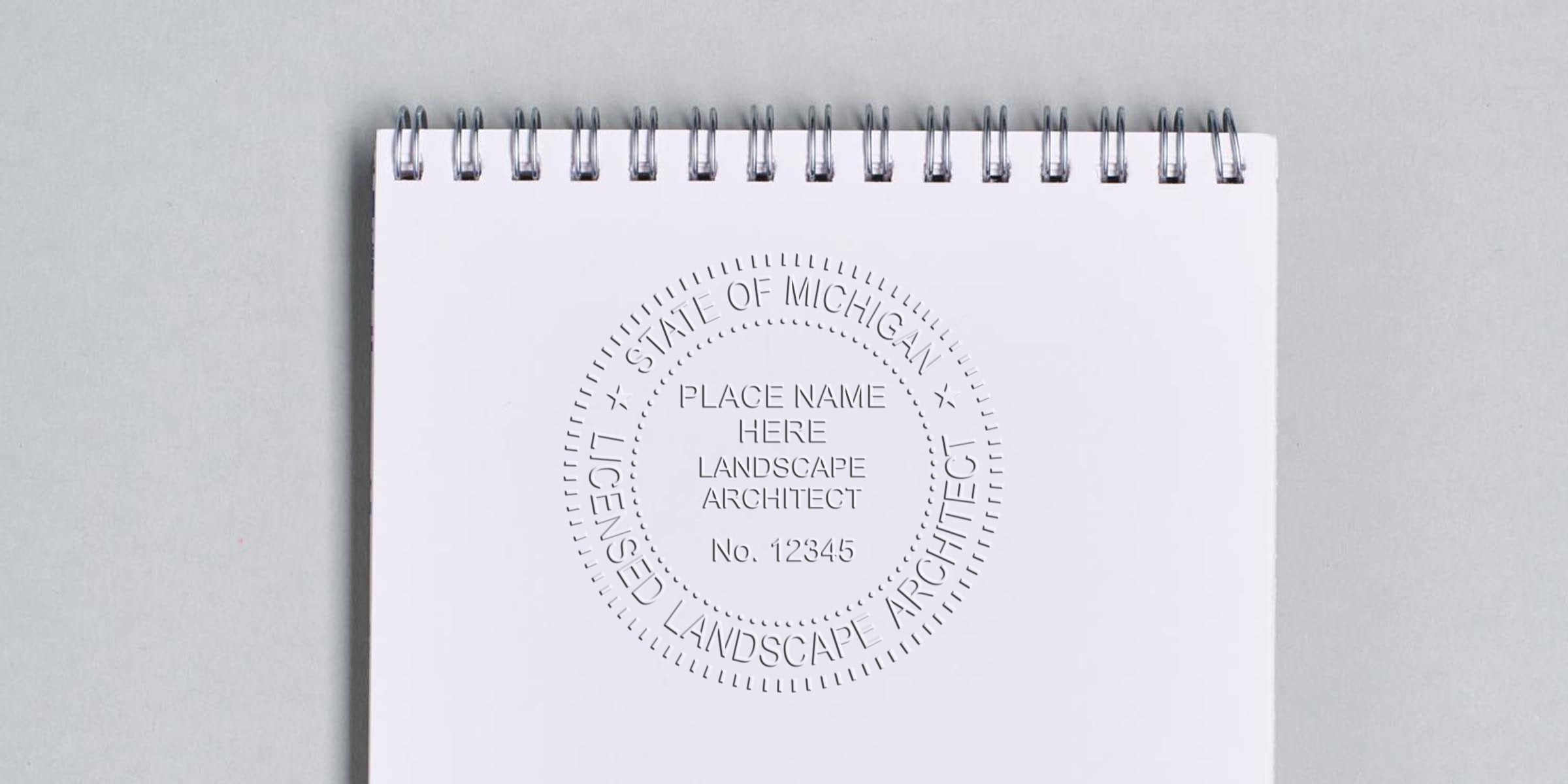 Embossed Michigan landscape architect stamp on white spiral notebook, licensed landscape architect seal, available as an online stamp.