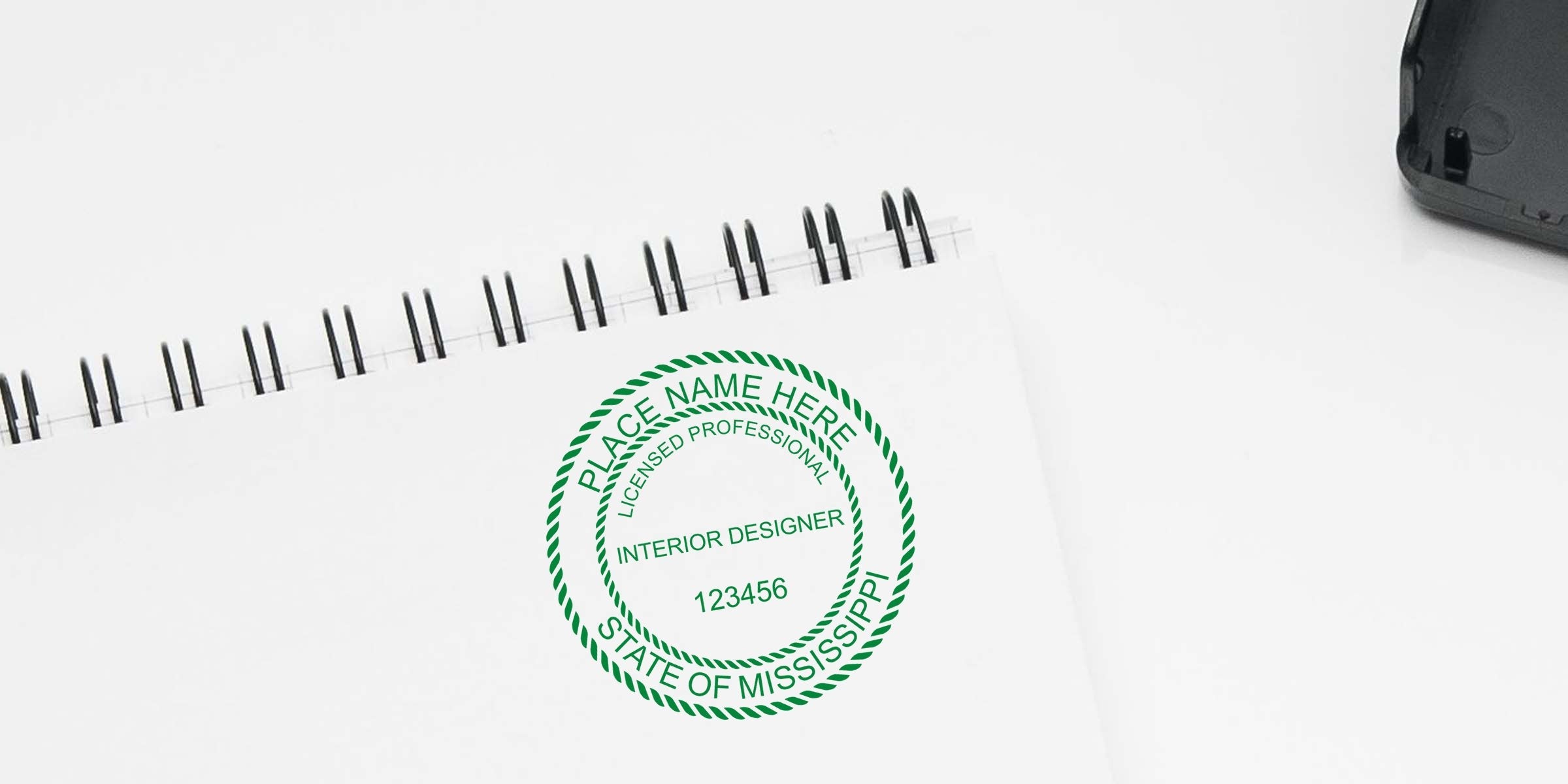 Licensed Mississippi interior designer stamp on white notebook, includes interior design stamp and purchase guide.