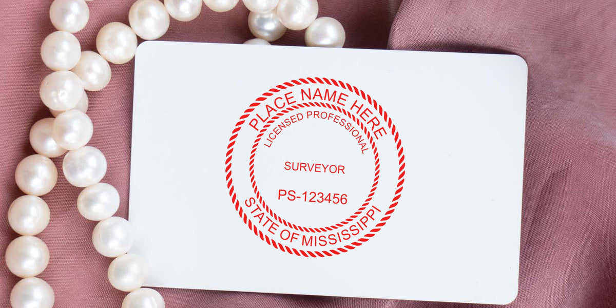Mississippi land surveyor seal embossed on a white card with a pearl necklace, showing the use of a land surveyor seal embosser.