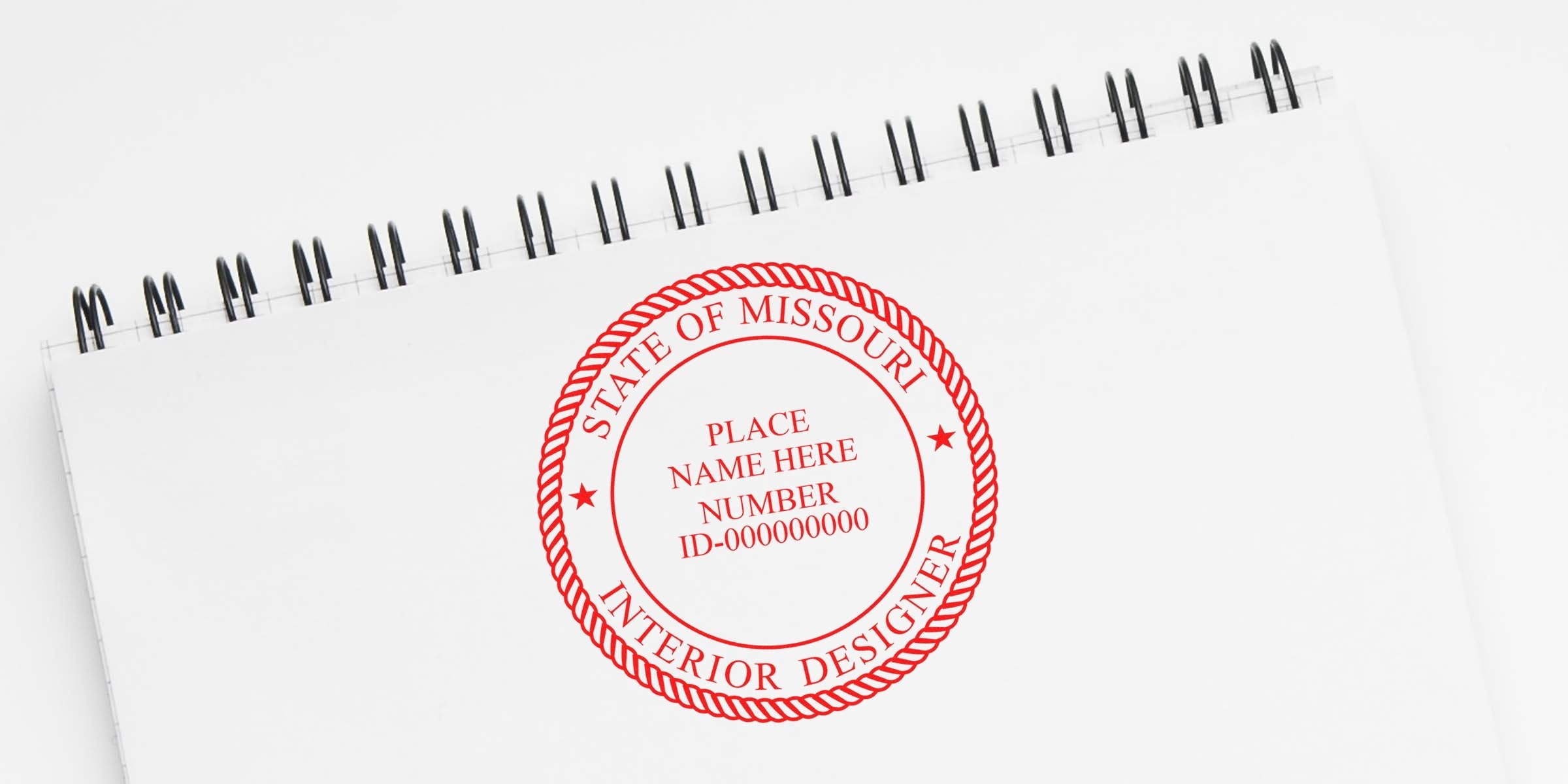 Missouri interior designer stamp on white spiral notebook for certification verification with ink tips.