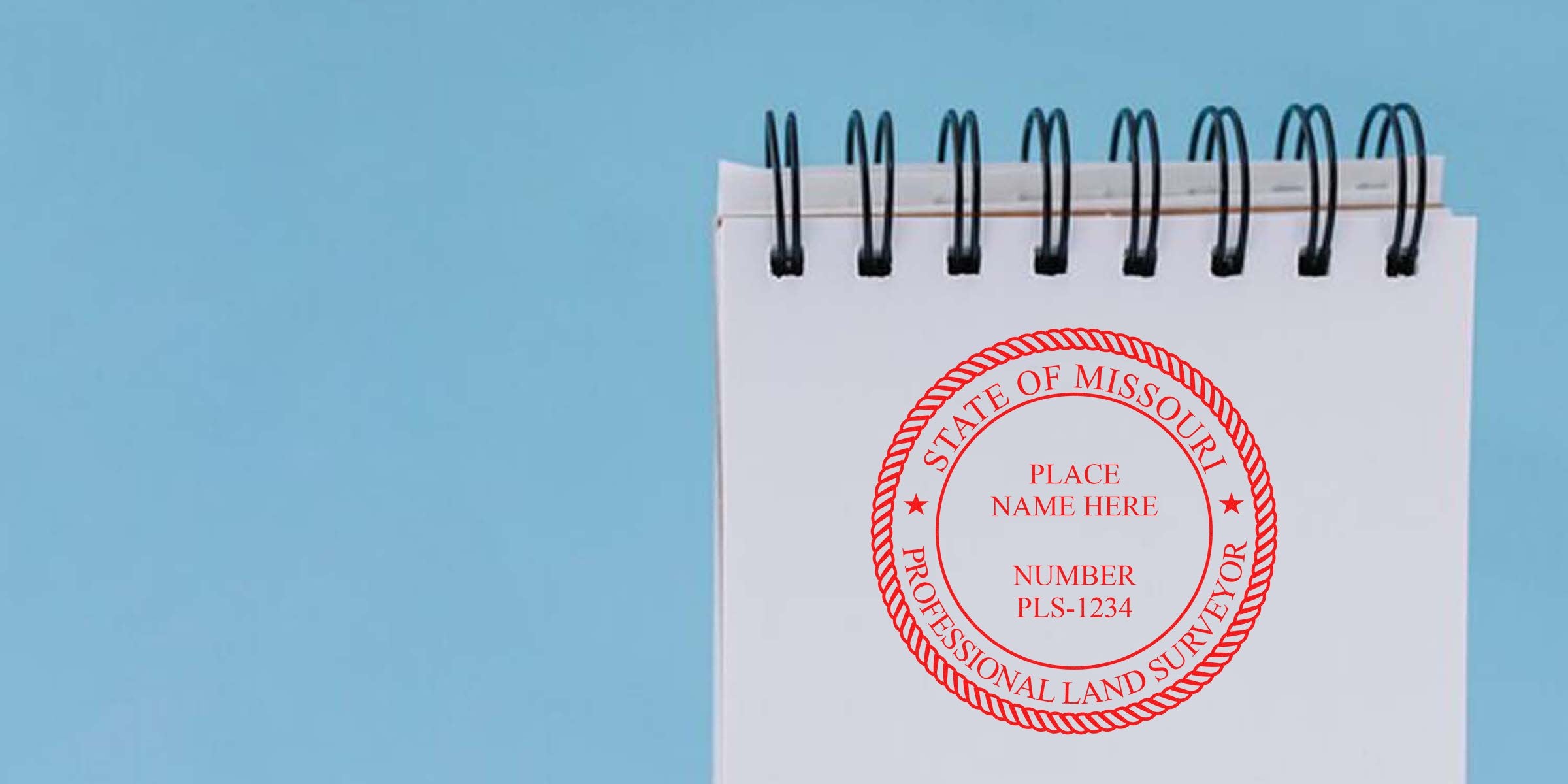 Missouri land surveyor stamp on a white spiral notebook with a blue background, showcasing custom surveyor stamp designs.