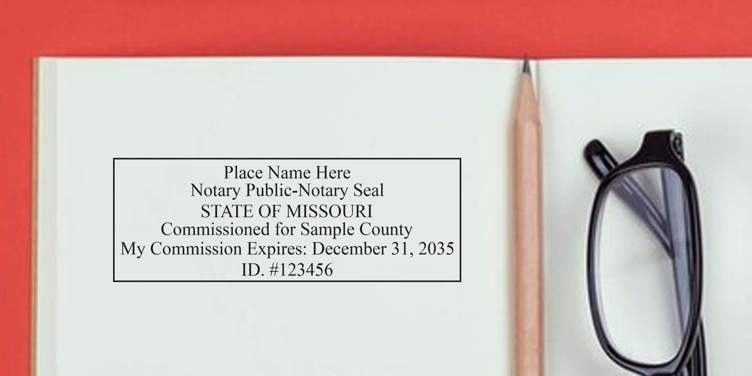 Missouri notary stamp and supplies shown with a notary seal, commission certificate, pencil, and glasses on an open notebook.