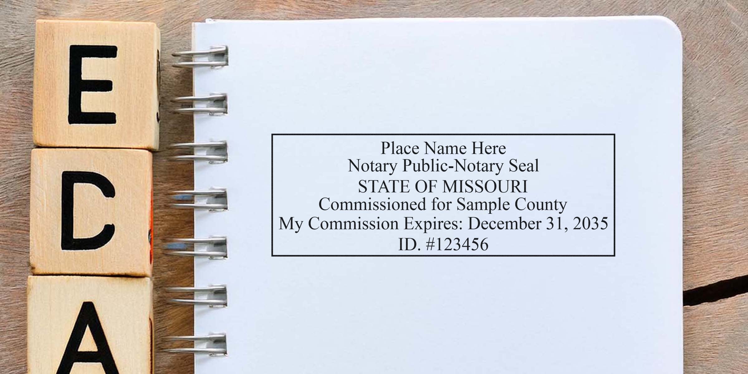 Missouri notary public commission certificate with official stamp, seal, and expiration date on a notebook next to wooden blocks spelling ECA.