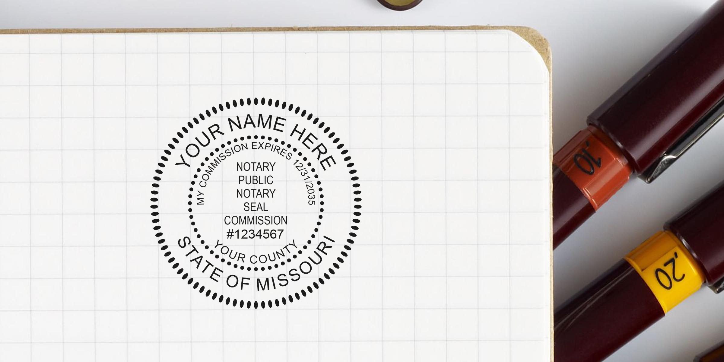 Missouri notary essentials with a notary public seal stamp on grid paper and pens, part of a full Missouri notary kit featuring the Missouri notary commission seal design.