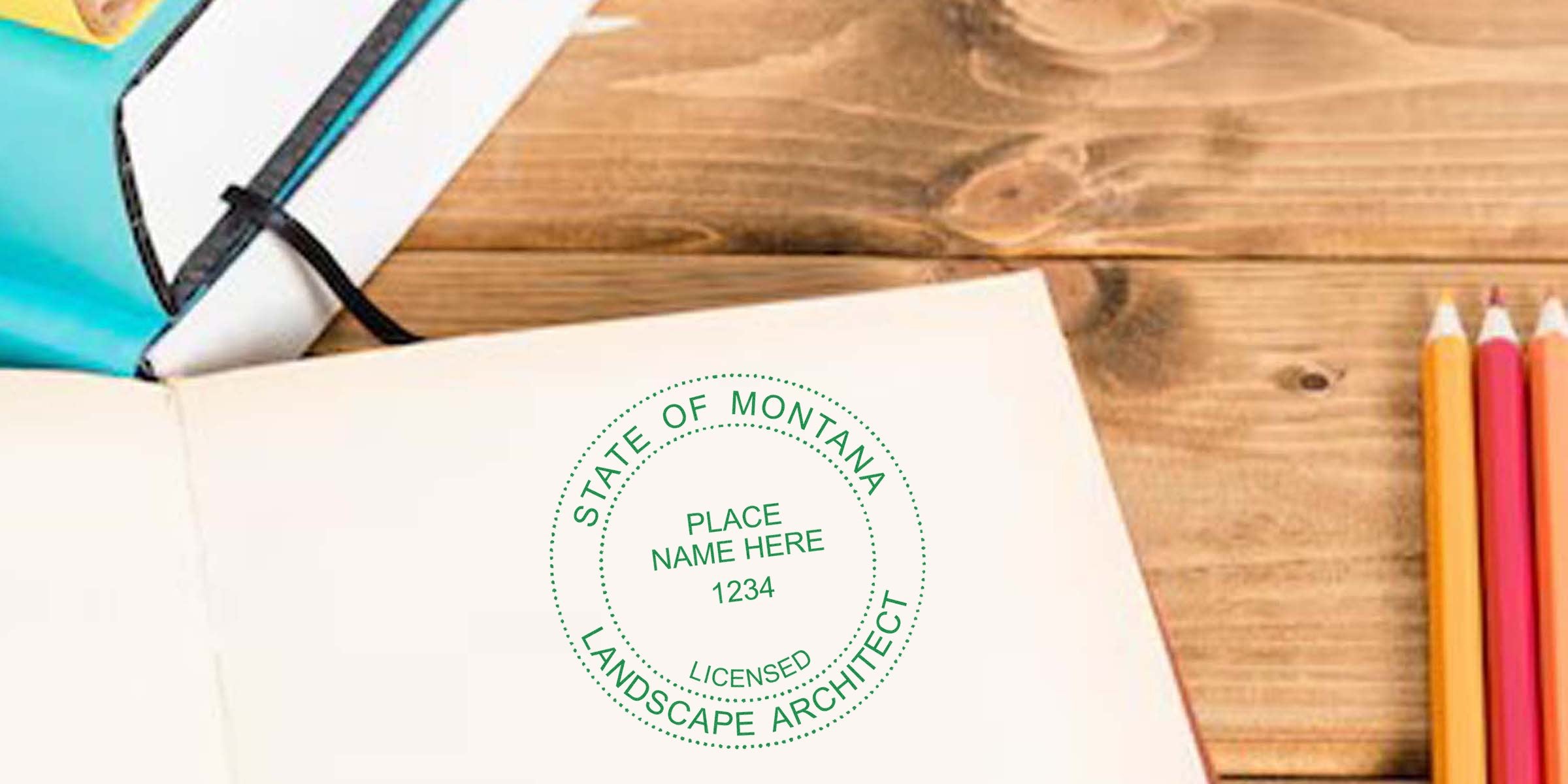 Open notebook with Montana landscape architect seal, colored pencils, and sketchbook on wooden desk for landscape architecture certification and design planning.
