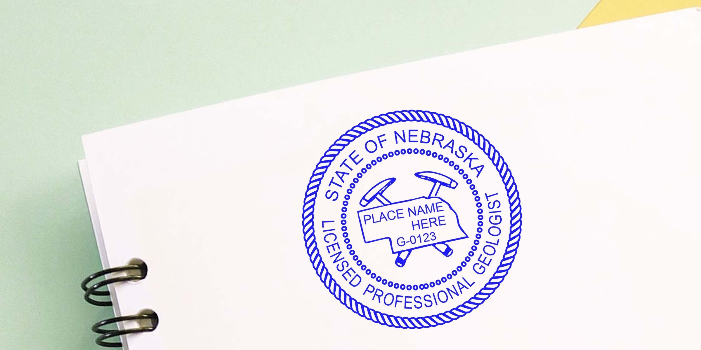 Affordable Nebraska geologist stamp on white notebook, perfect for geology certification.