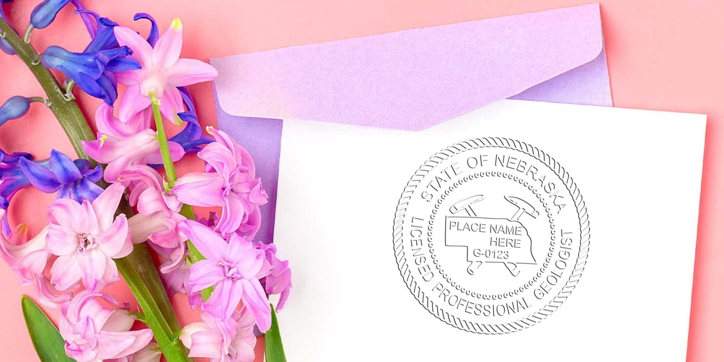 Nebraska geologist seal embossed on white paper with a professional geologist stamp, placed next to a purple envelope and pink and purple flowers on a peach background.