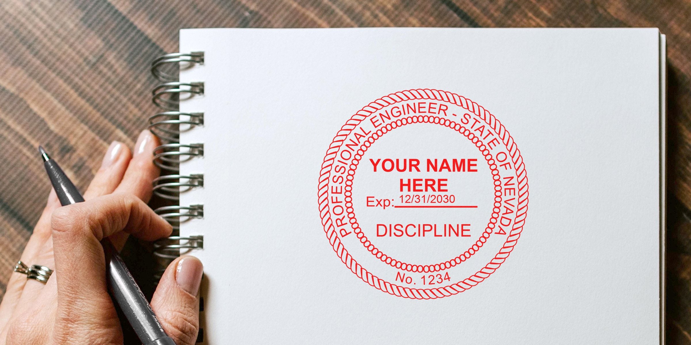 Hand holding pen next to Nevada engineer seal embosser, emphasizing professional certification, licensing, and engineer seal embosser reviews.