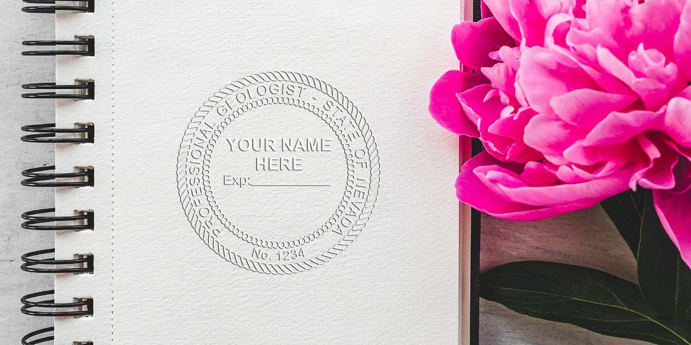 Nevada geologist stamp embossed on textured paper next to a bright pink peony and green leaves on a wooden surface.