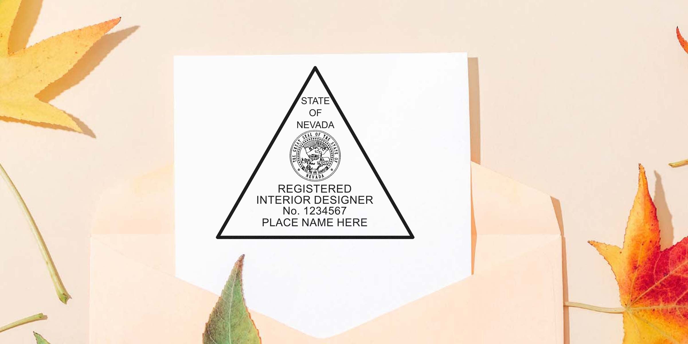 Nevada interior designer certificate with embossed seal on white paper, surrounded by autumn leaves and an envelope with an interior designer embosser nearby.