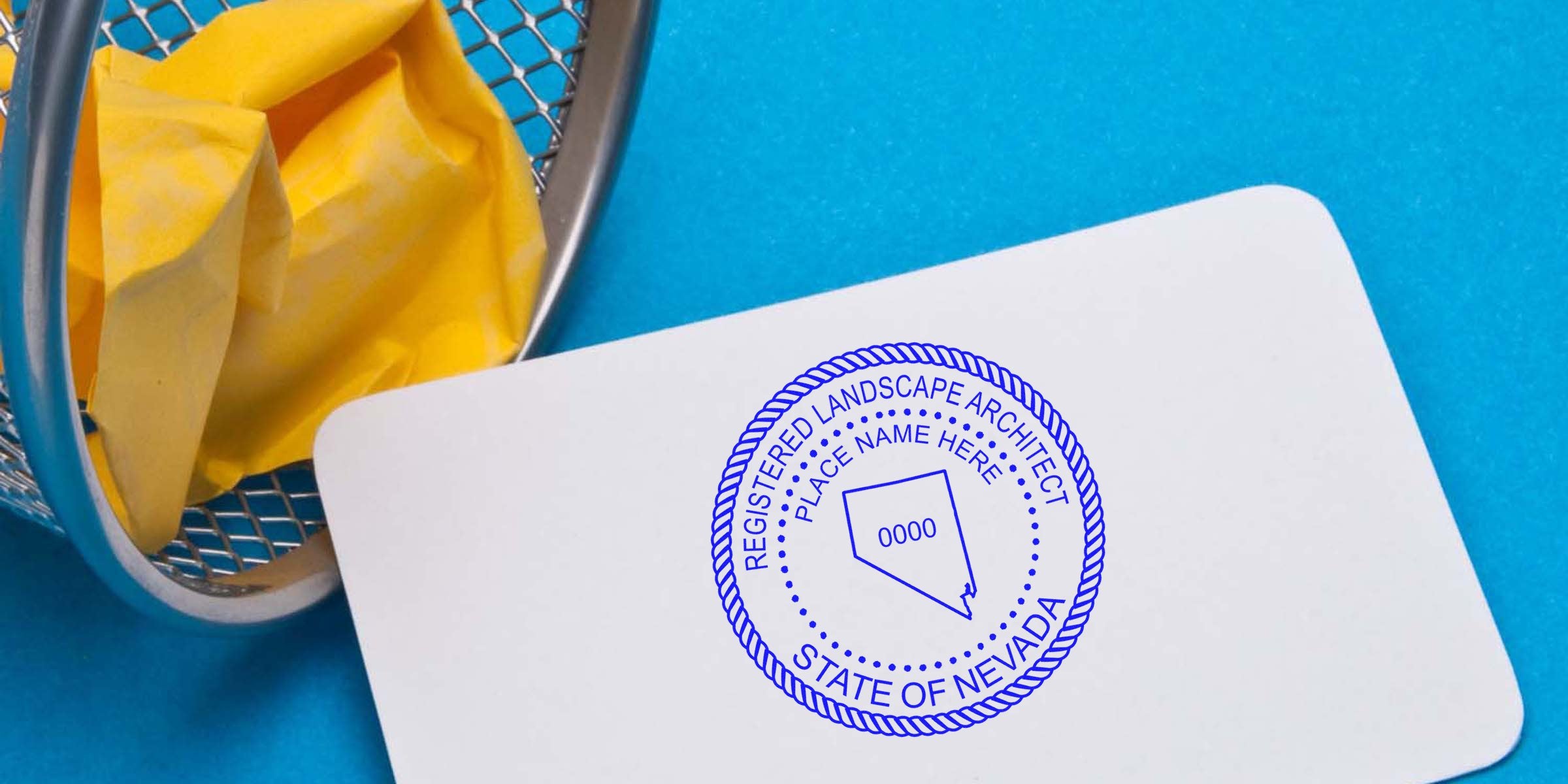 Nevada landscape architect stamp on white card next to yellow crumpled paper in metal trash bin on blue background, symbolizing Nevada landscape architect licensing.