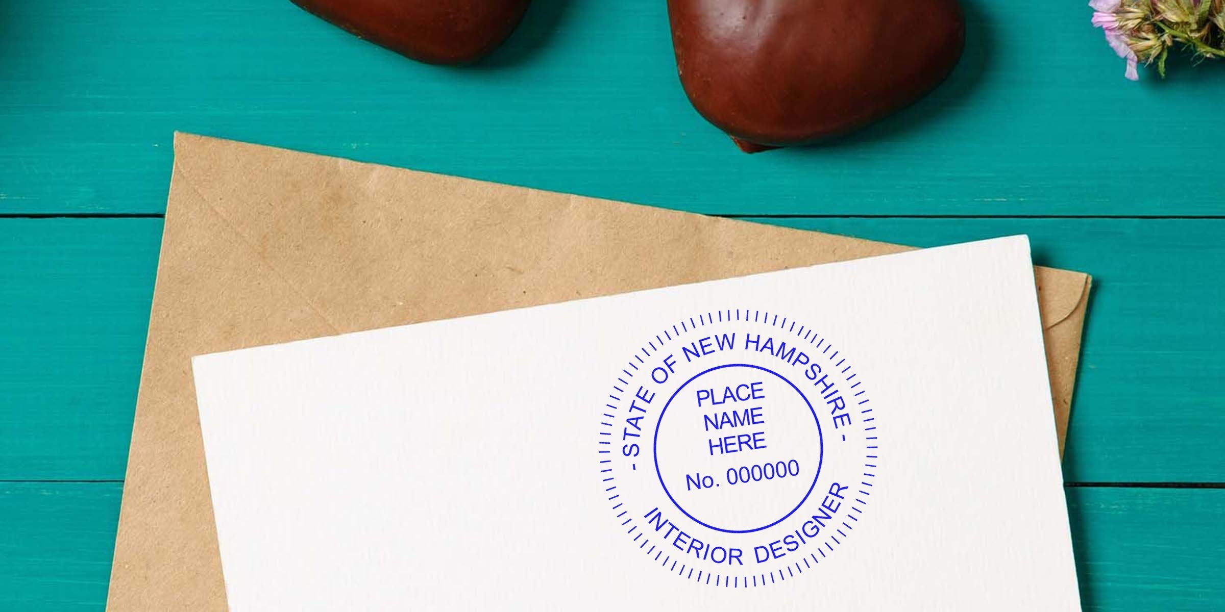 Envelope with New Hampshire interior designer stamp and heart decorations on teal wood, highlighting NH stamp regulations and understanding New Hampshire stamp laws.