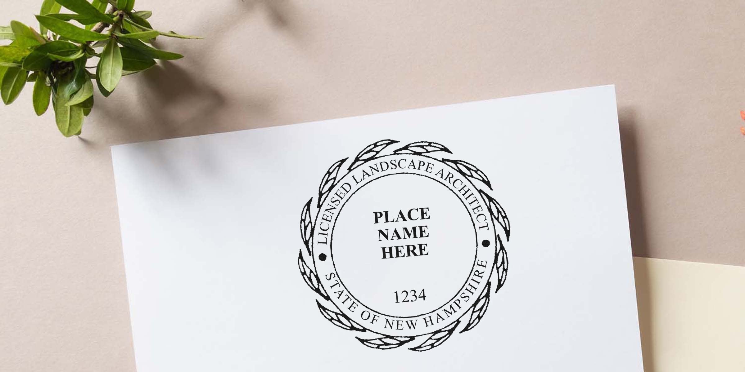 New Hampshire licensed landscape architect seal on white paper with green leaves nearby, revealing design secrets of the NH landscape architect seal.