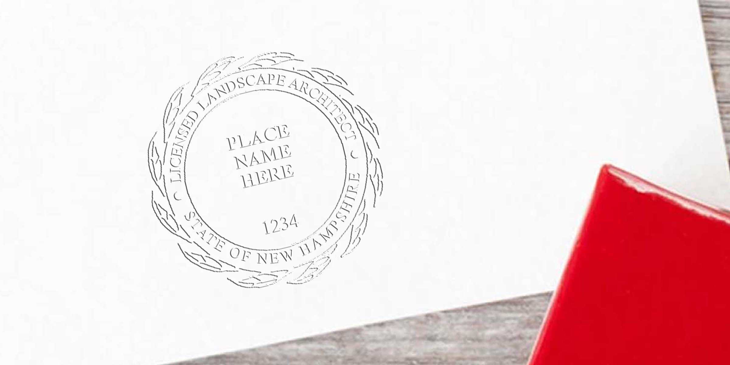 New Hampshire landscape architect licensed stamp on white paper with red handle, displaying landscape architect seal details.
