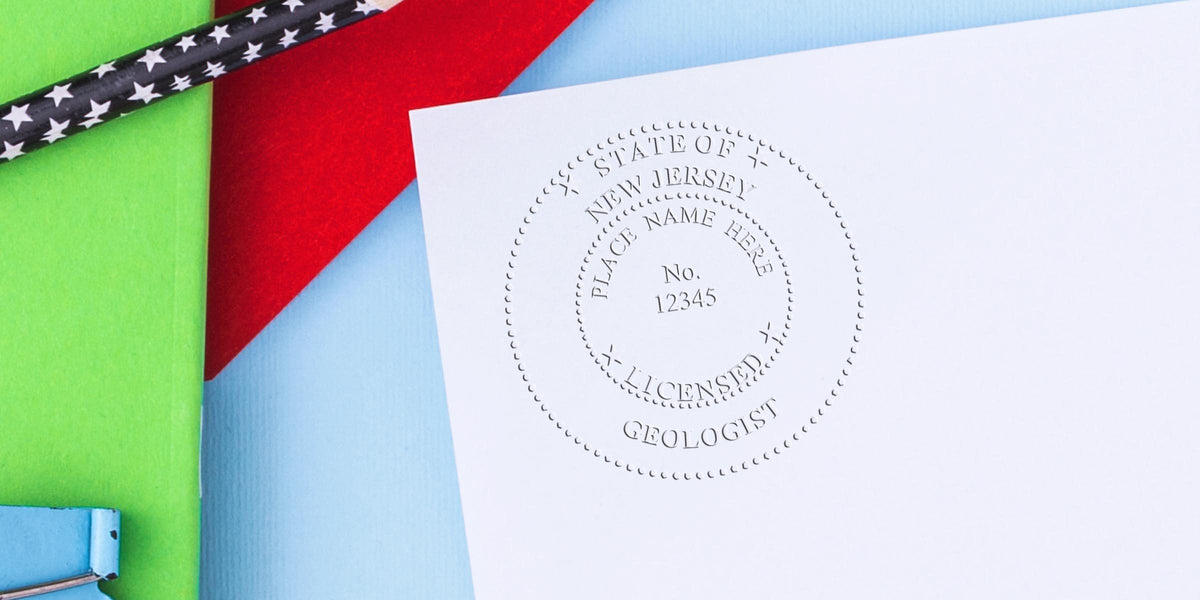 Custom New Jersey Geologist Stamp with licensed embossed seal on white paper, set against a colorful background and star-patterned pencils, highlighting the NJ Geologist Stamp design.