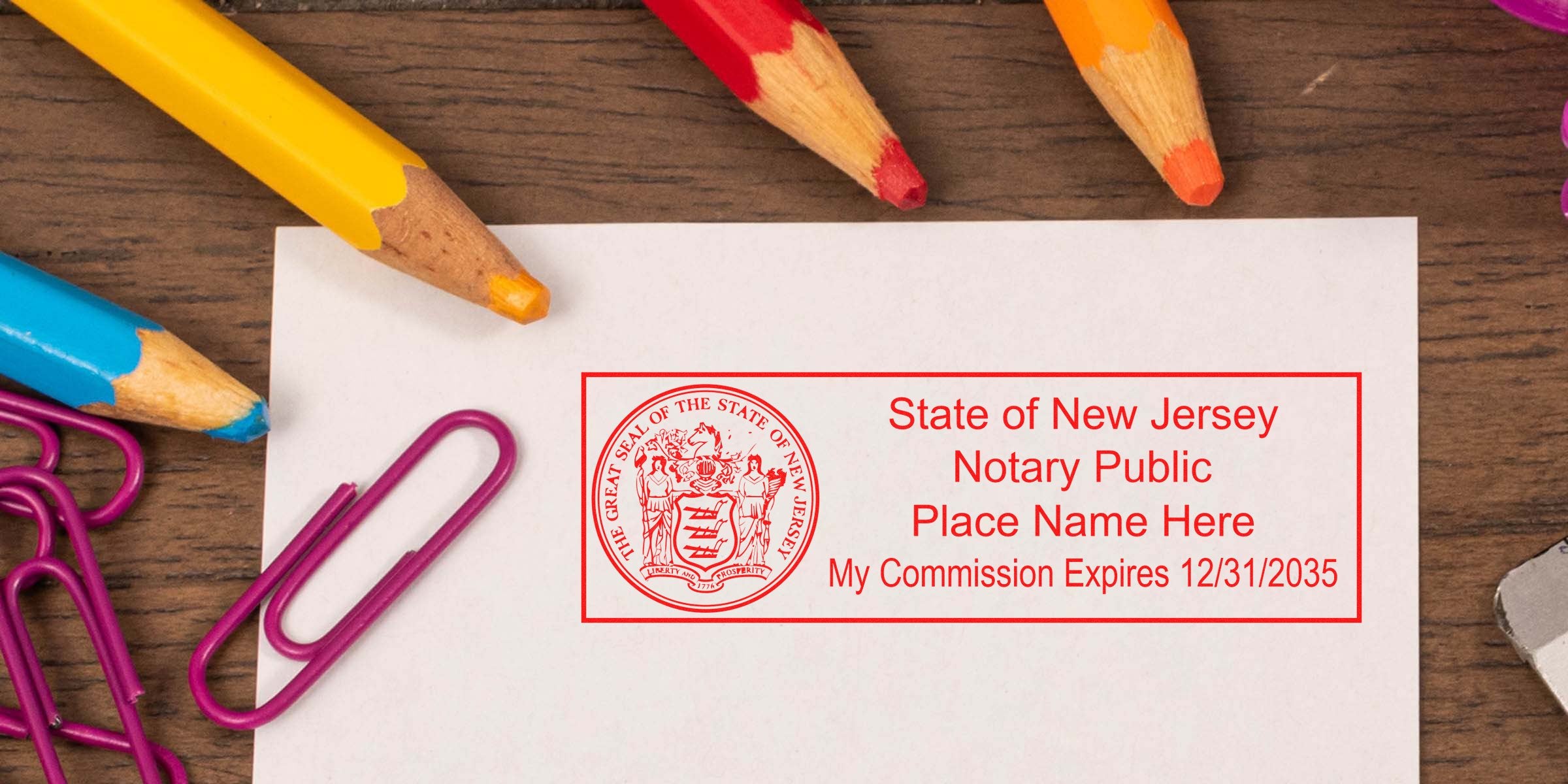 New Jersey notary public stamp with commission expiration on white paper, surrounded by colorful pencils and purple paper clips, highlighting essential NJ notary supplies and tools.