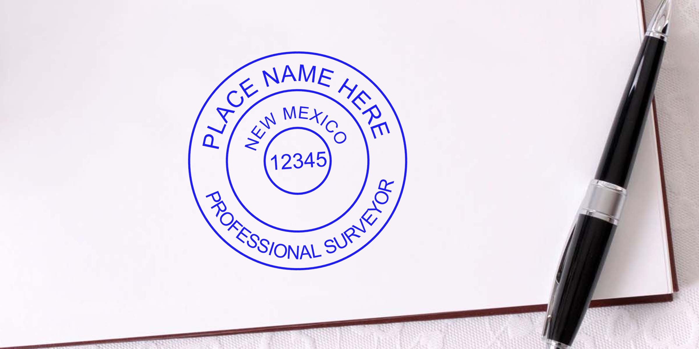 New Mexico land surveyor stamp with pen on white paper, perfect for professionals seeking to purchase a land surveyor stamp.