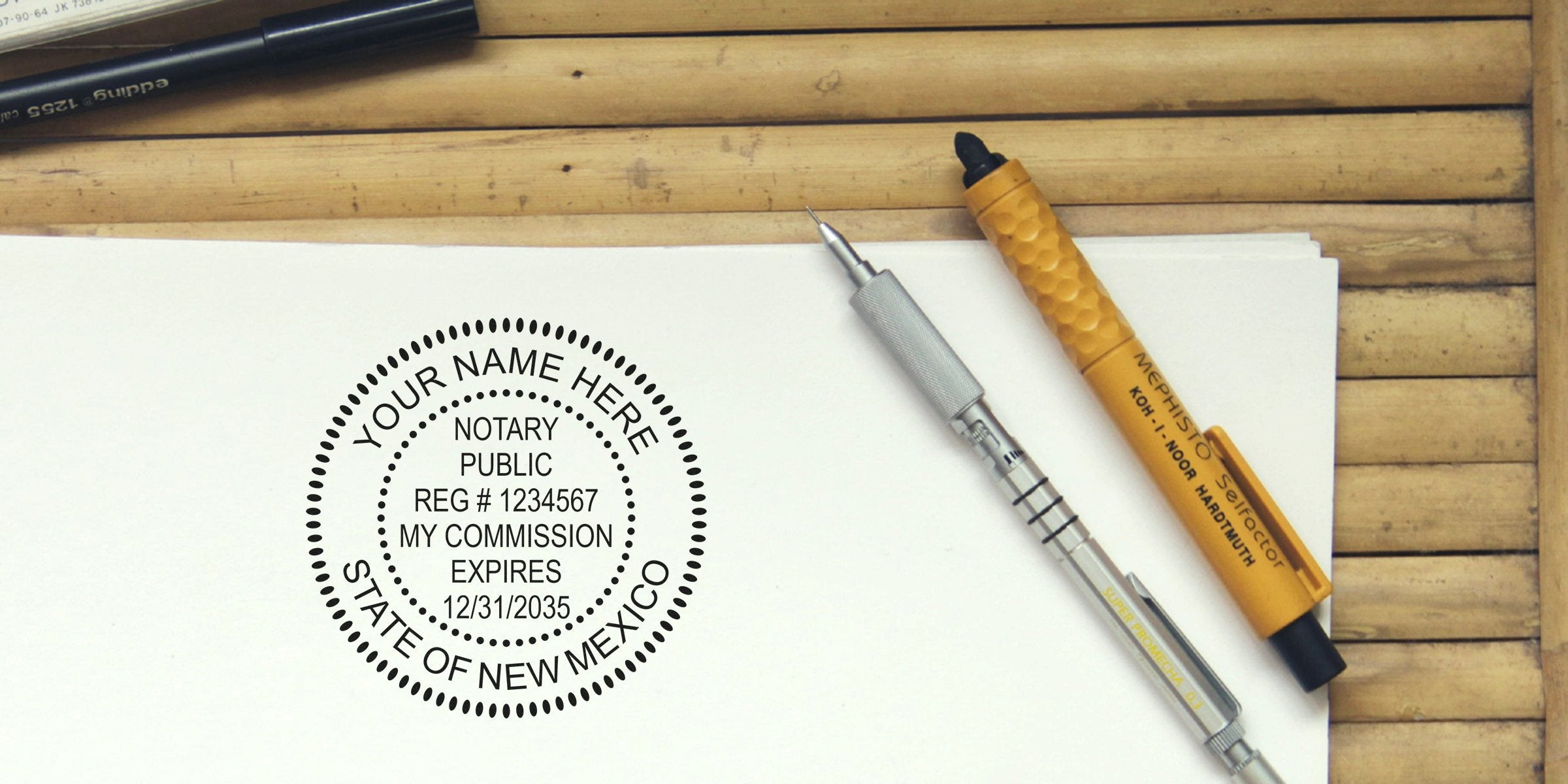 NM notary stamp and New Mexico notary seal with commission expiration date on white paper next to pens