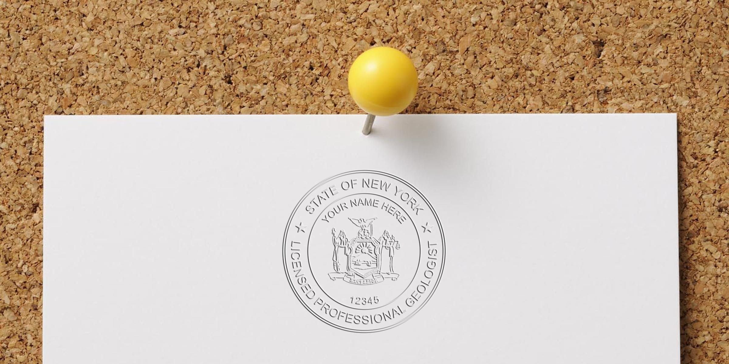 New York professional geologist seal pinned on corkboard with yellow pushpin, showing the official New York geologist stamp.