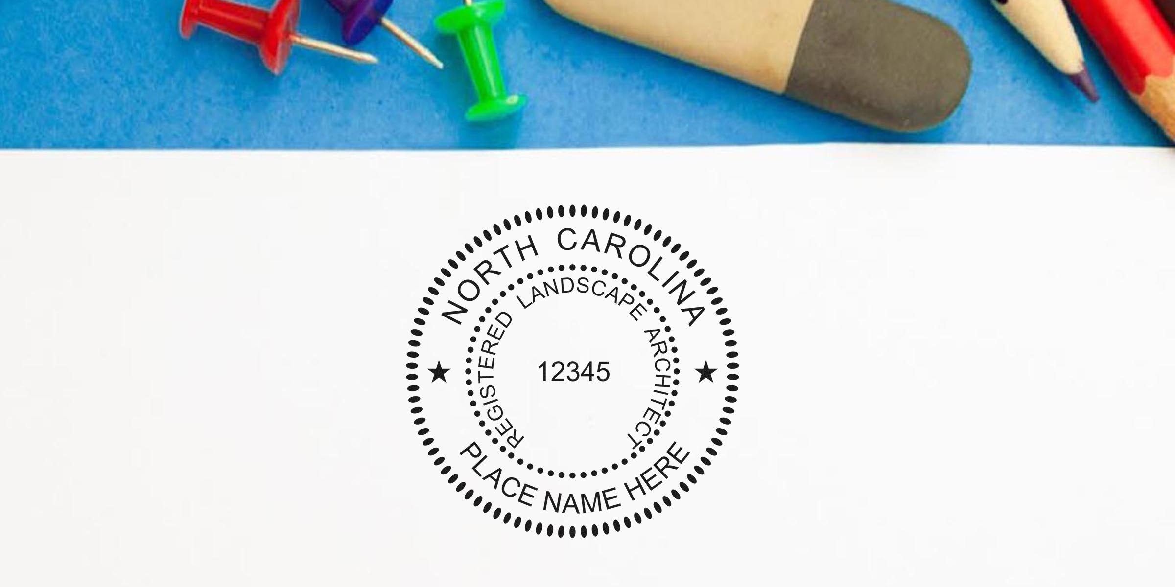 North Carolina landscape architect seal and registration number on white paper, surrounded by colorful push pins and pencils, featuring NC landscape architect seal and embossers.