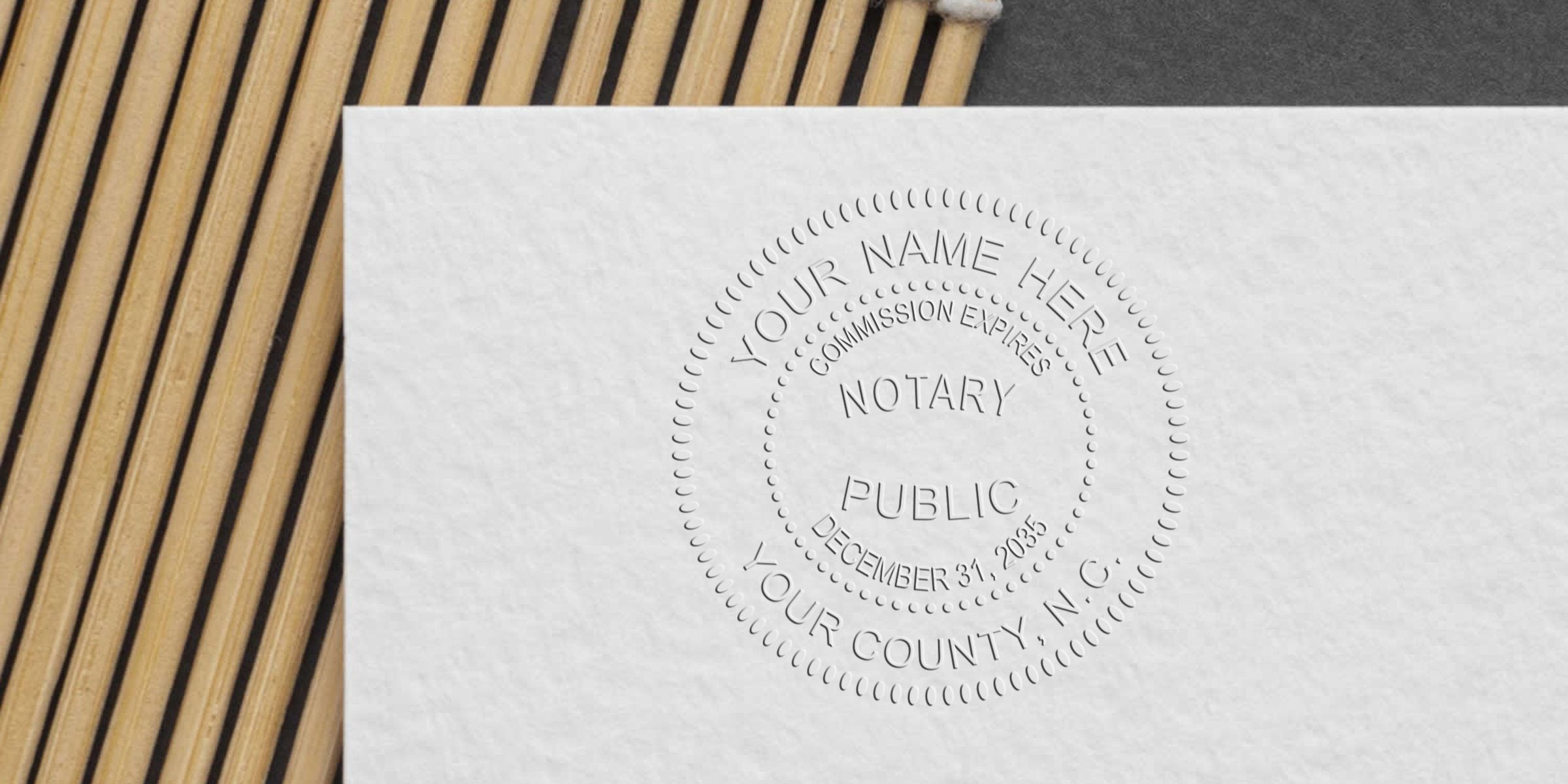 Embossed notary public seal on white paper for official document certification, included in the North Carolina Notary Kit and referenced in the NC Notary Starter Guide.
