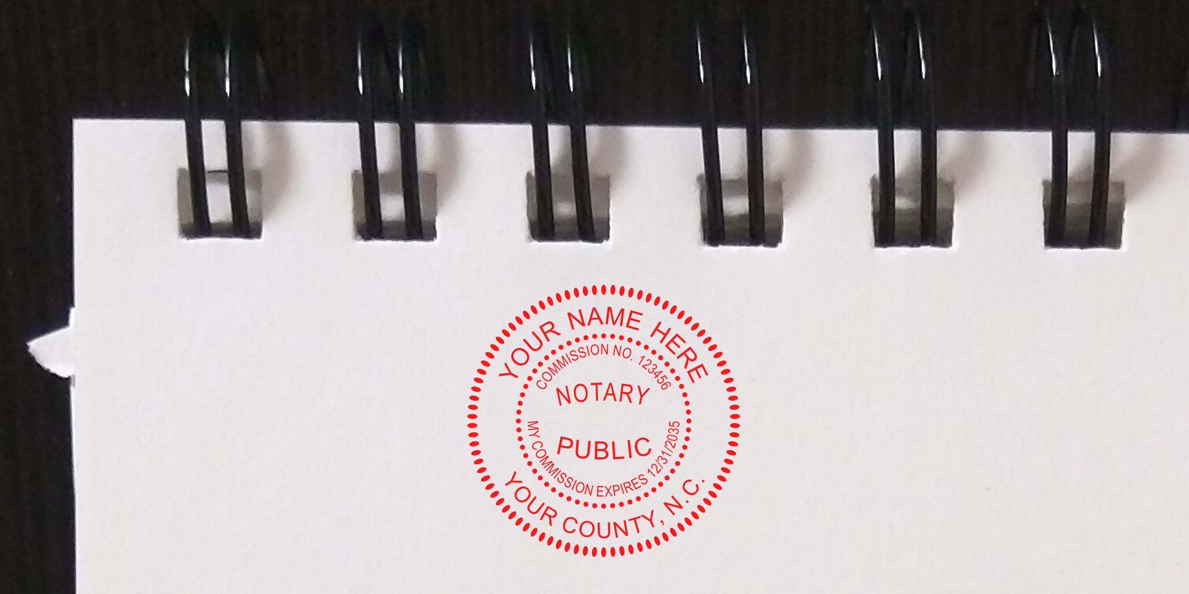 North Carolina notary stamp on white spiral notebook page showing commission details and county, featured in the official notary guide.
