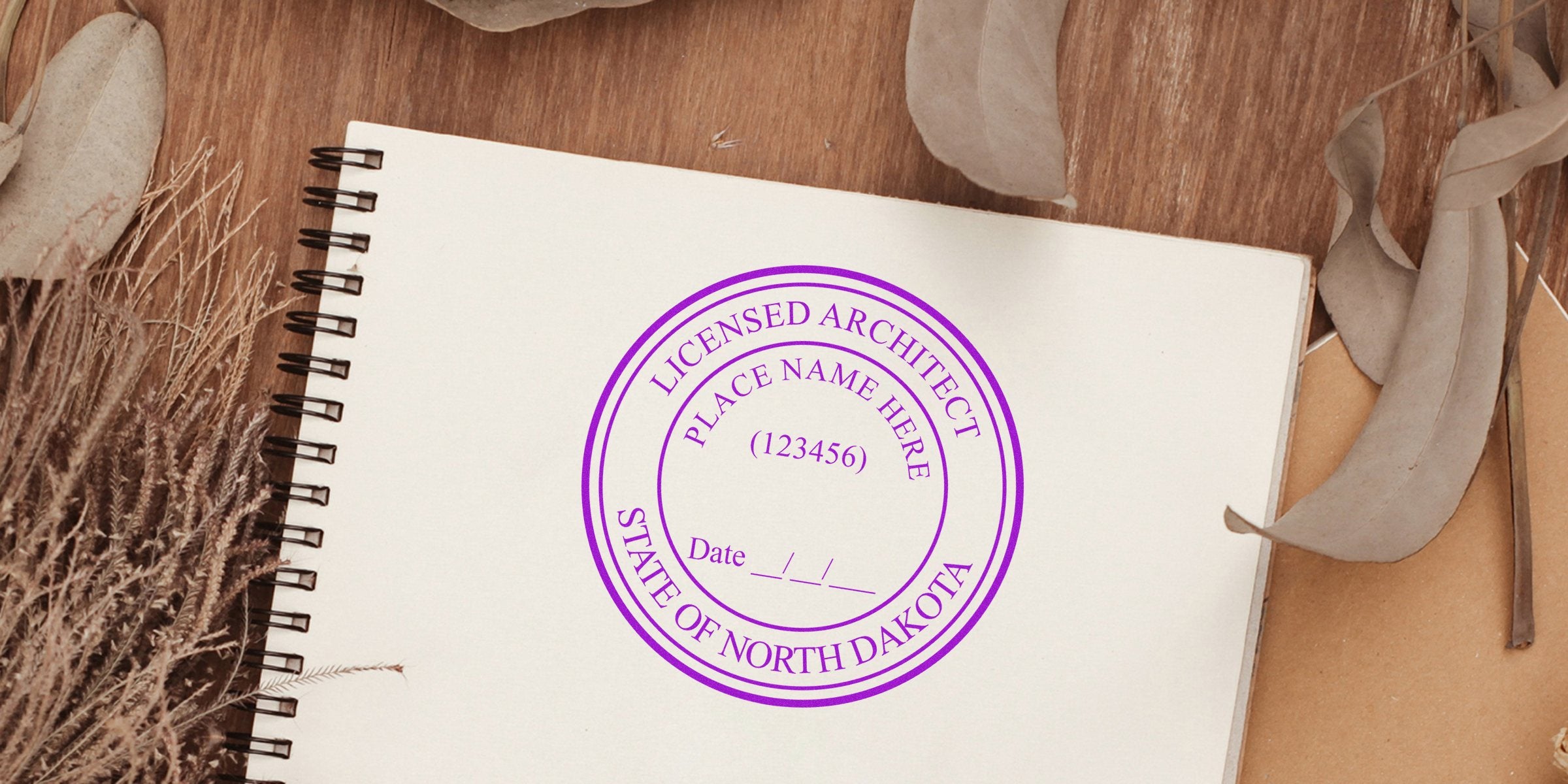 North Dakota architect stamp on notebook with dried leaves and rustic background, showcasing North Dakota architect stamp requirements.